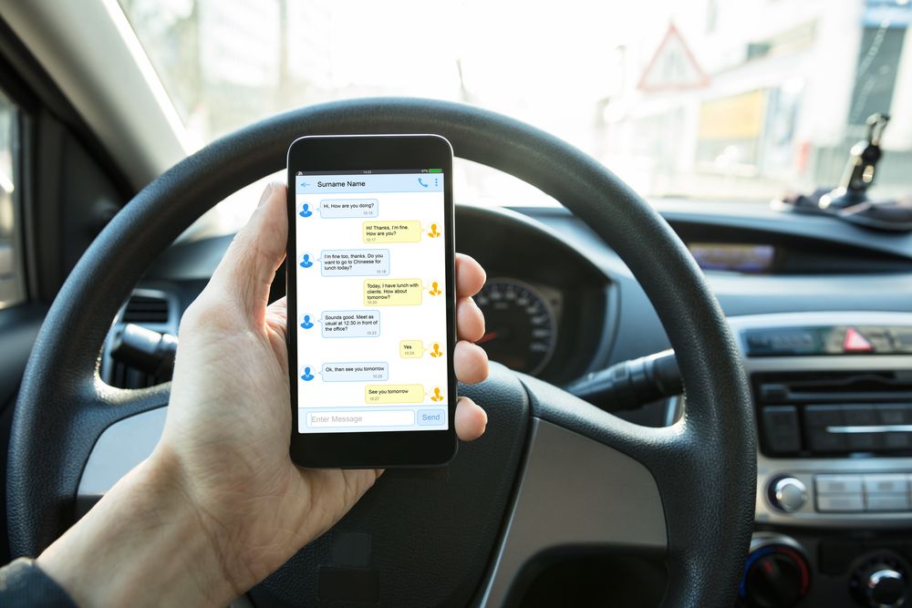 A man texting while driving. | Source: Shutterstock