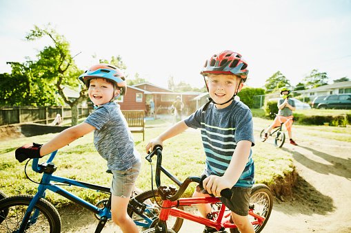 Photo of young boys preparing to ride BMX bikes on dirt track in backyard | Photo: Getty Images