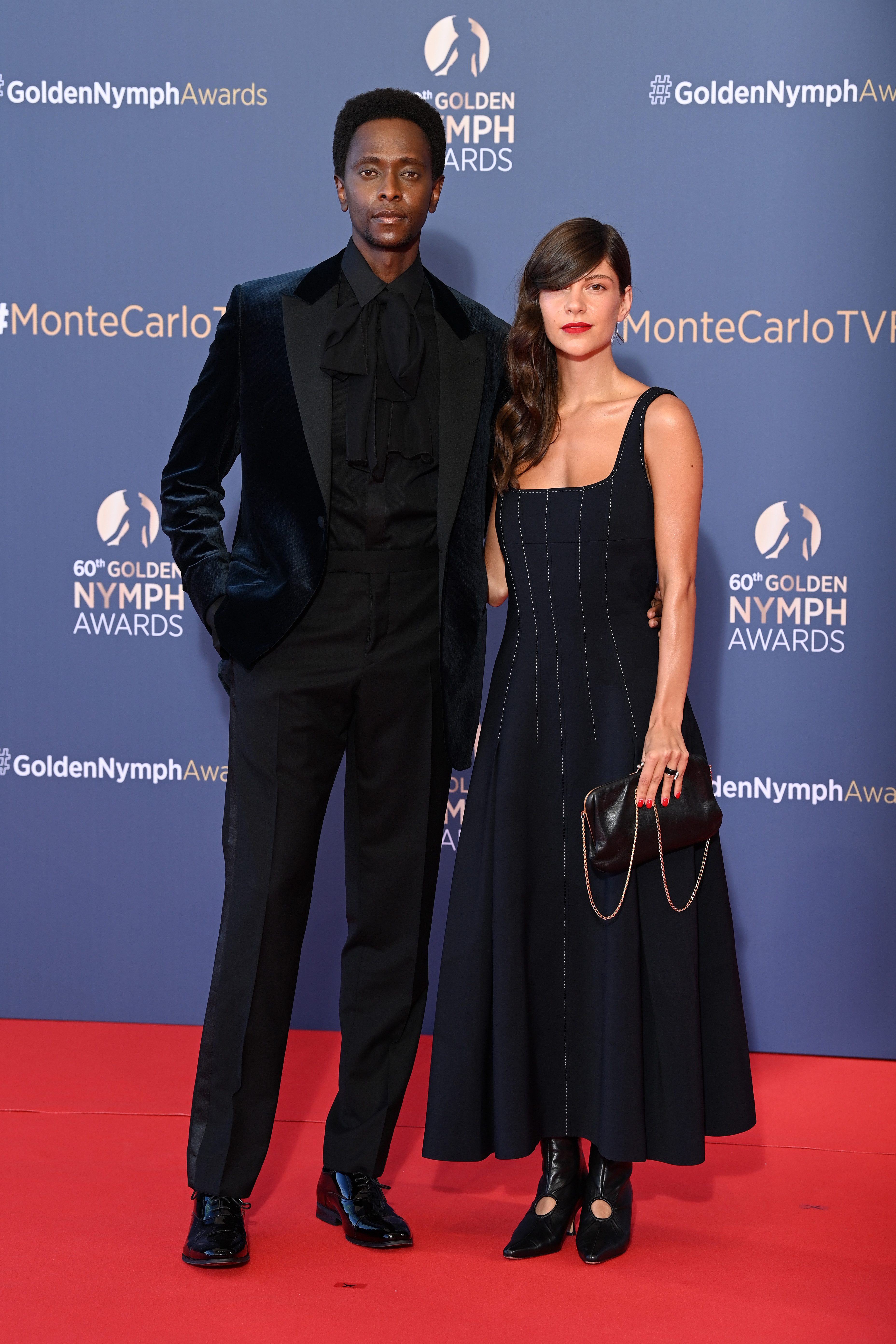 Edi Gathegi and Adriana Marinescu pose as they arrive at the closing ceremony of the 60th Monte Carlo TV Festival on June 22, 2021, in Monte-Carlo, Monaco | Source: Getty Images