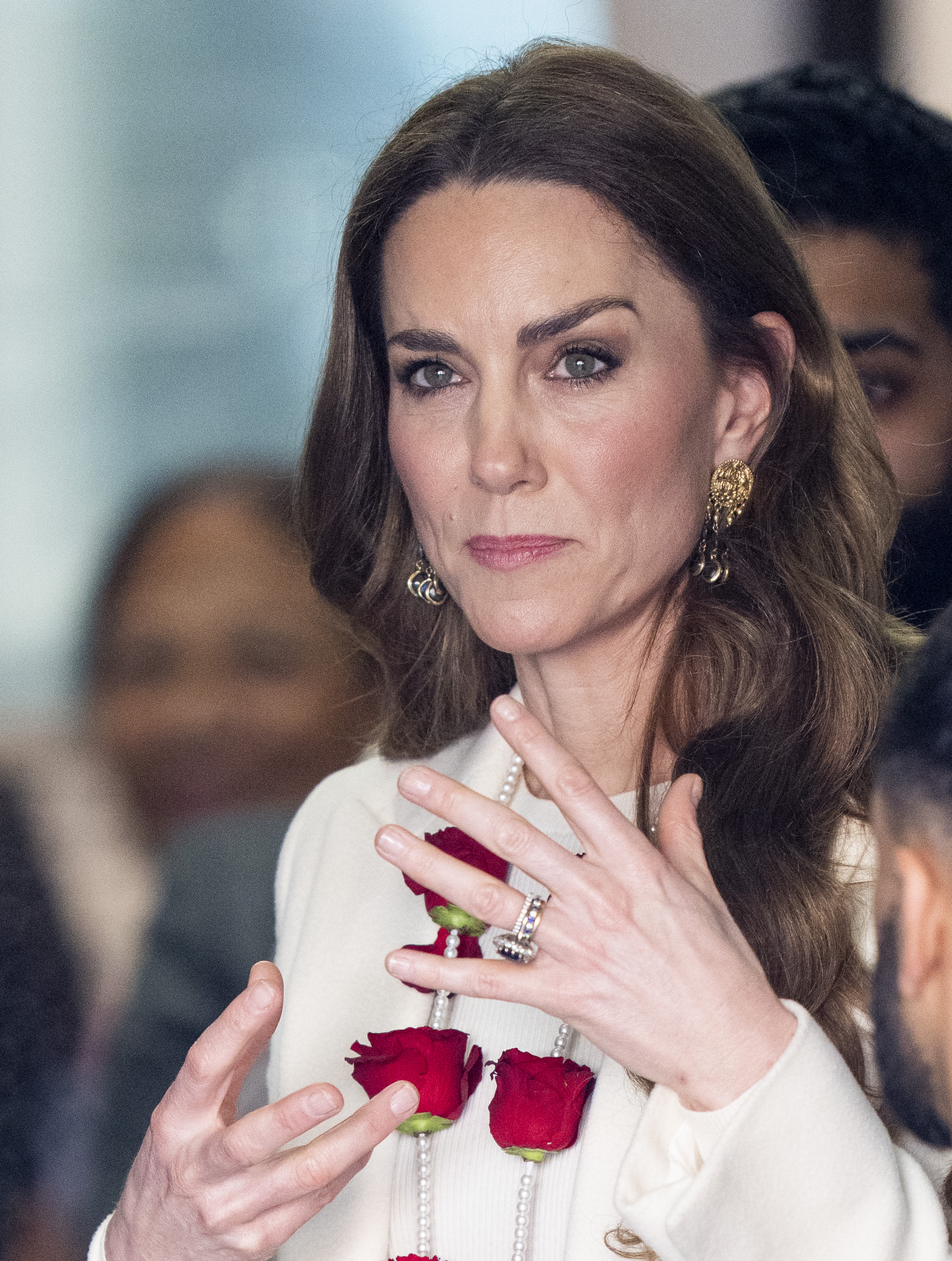 Catherine, Princess of Wales, speaks animatedly with performers and organisers during her engagement at the Aakash Odedra Company in Leicester on March 5, 2026. Still wearing the floral garland presented to her earlier, the Princess of Wales gestures as she listens and responds to those gathered, appearing deeply engaged in conversations about the dance company's work within the community.