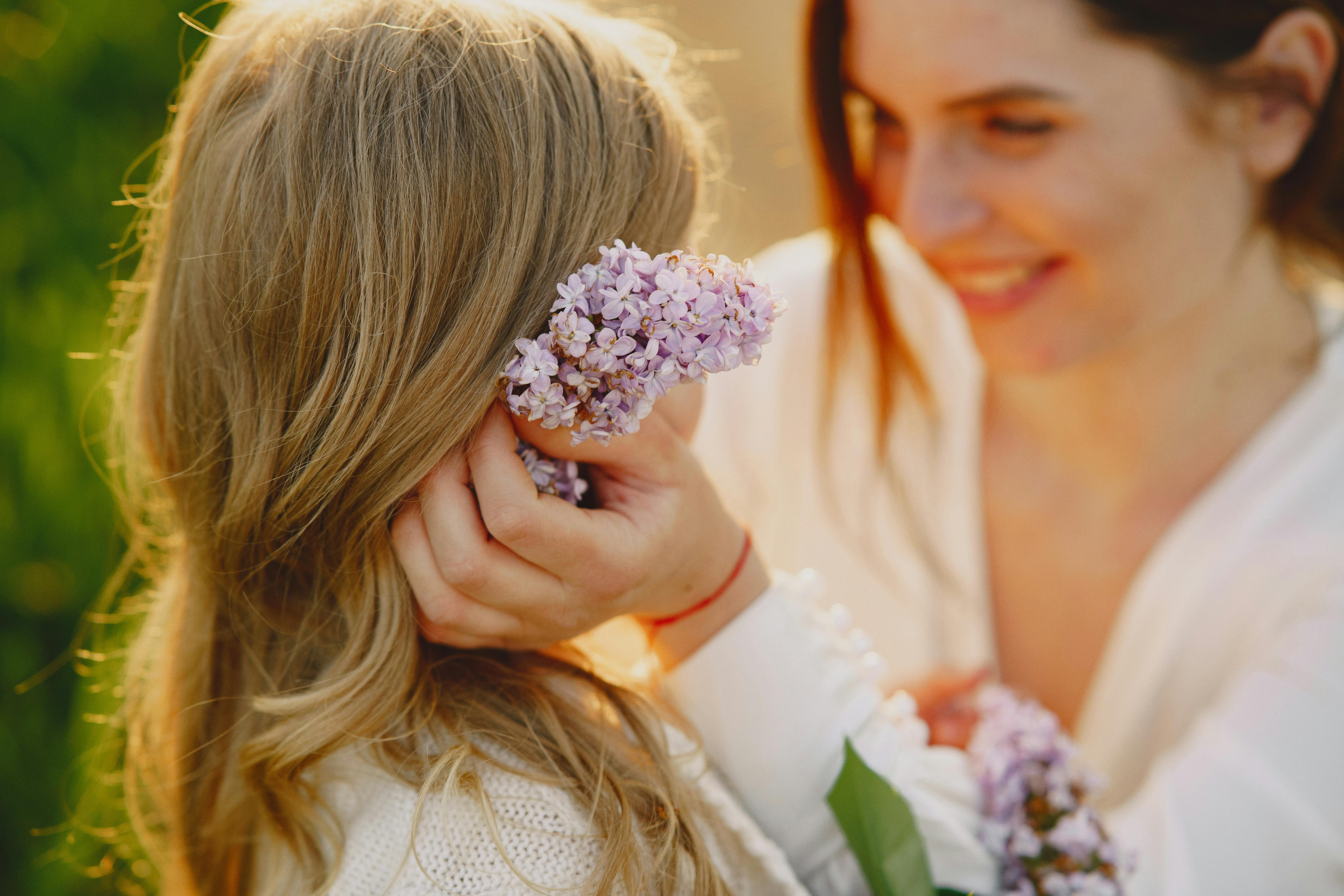 Woman putting flowers on her daughter's hair | Source: Pexels