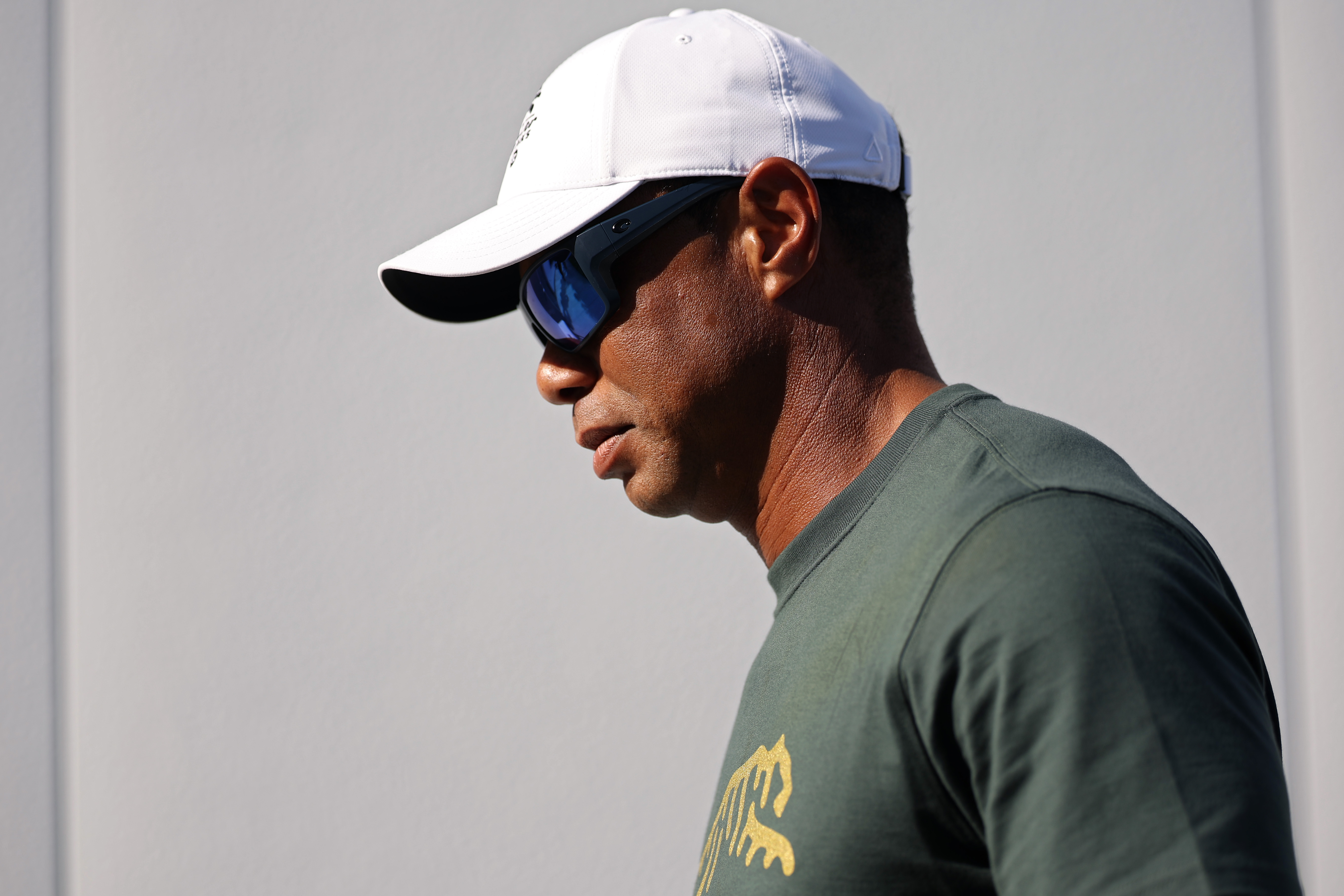 Tiger Woods walks in profile wearing a cap and sunglasses at the TGL Finals in Palm Beach Gardens Florida on March 24, 2026 | Source: Getty Images