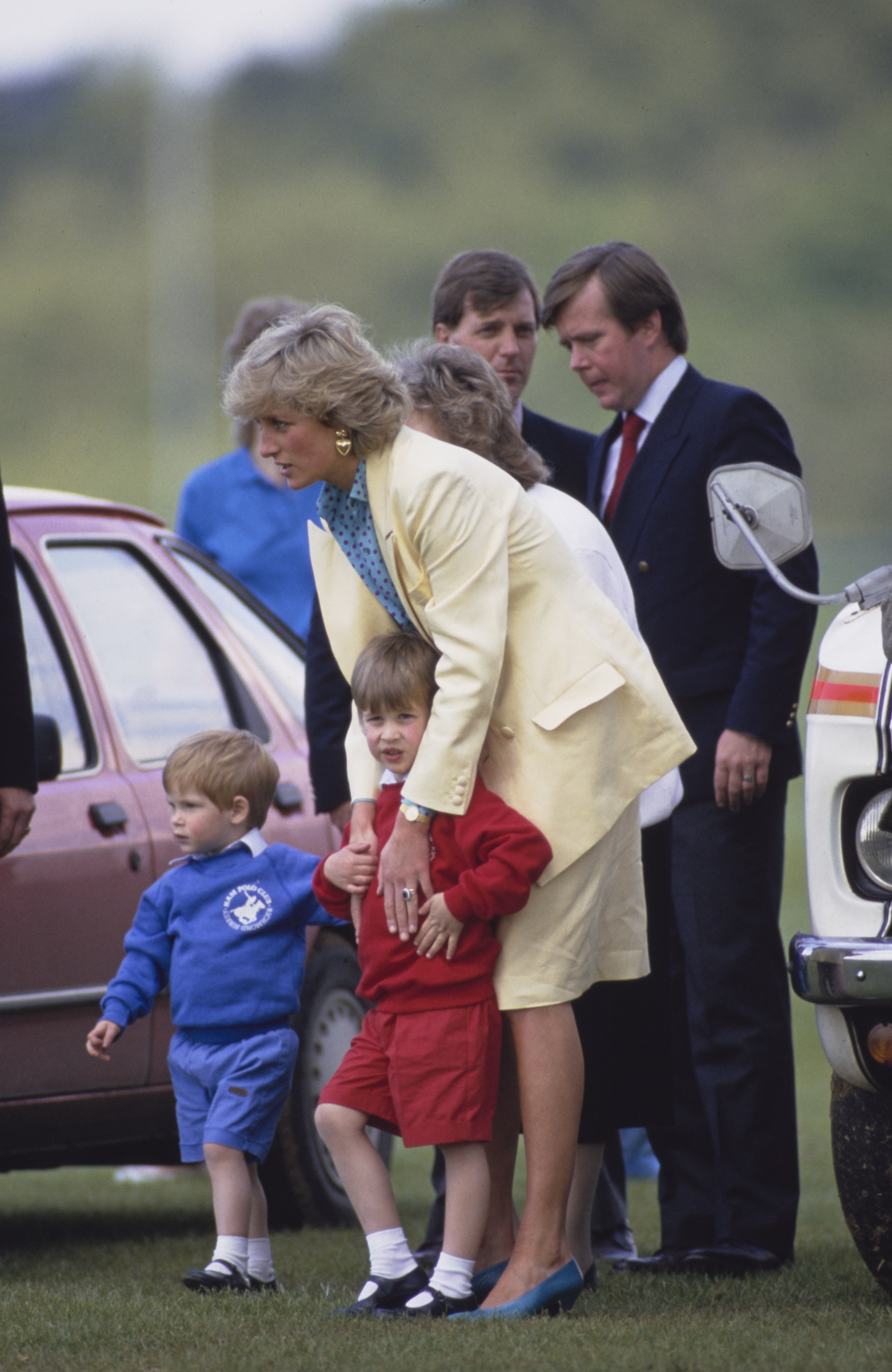 Princess Diana and her sons Prince Harry and Prince William and Diana's Royal Protection Officer Ken Wharfe in the background, on the right, at the Guards Polo Club in Windsor Great Park, Berkshire on May 31, 1987 | Source: Getty Images