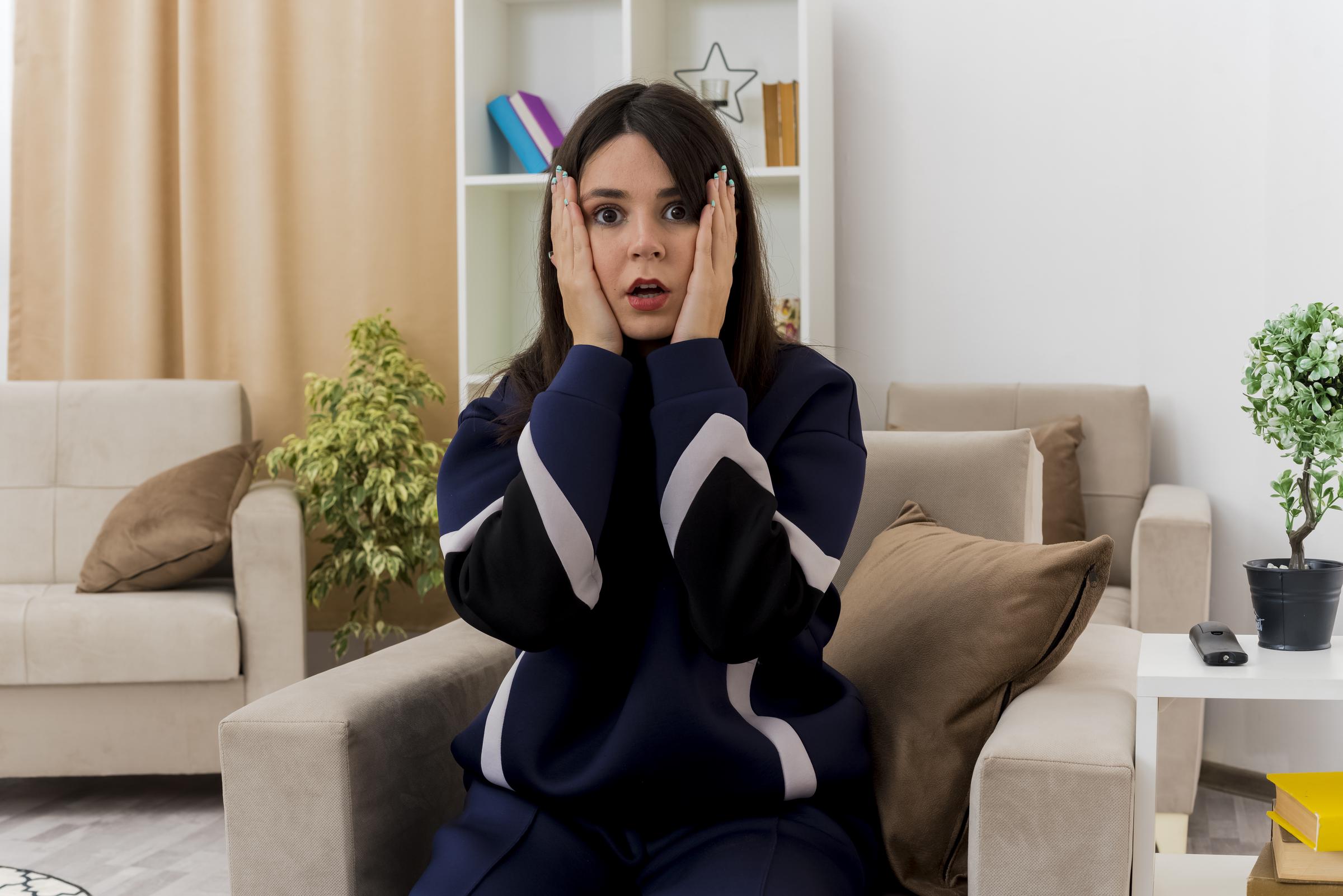 A shocked young woman holding her face | Source: Freepik