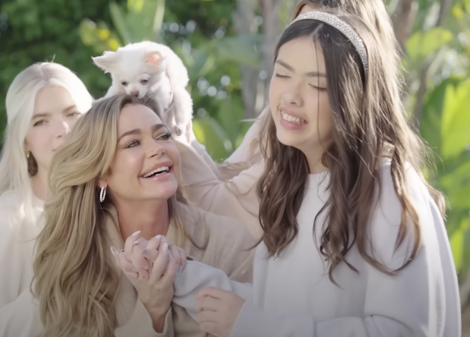 Denise Richards holding Eloise Richard's hand as the two smile with Lola and Sami Sheen, and the family dog behind them. | Source: YouTube/People