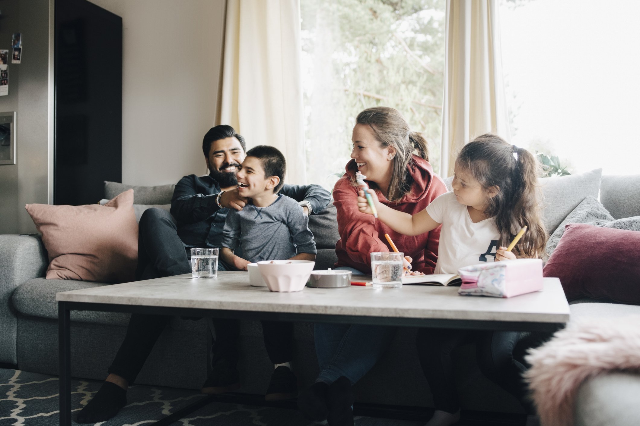 Happy family spending leisure time in living room|Photo: Getty Images