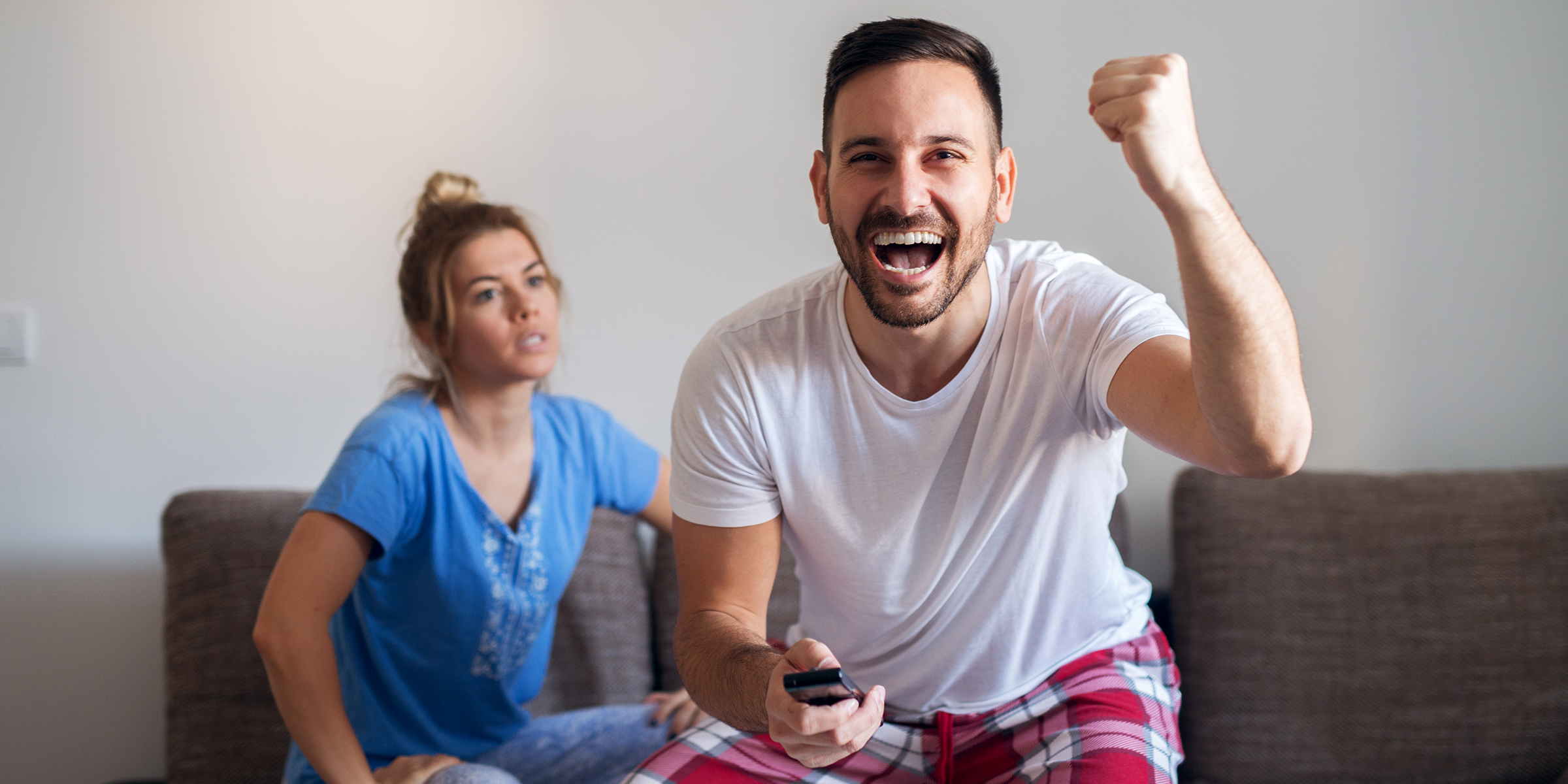 A woman looking at her husband while he's watching TV | Source: Shutterstock