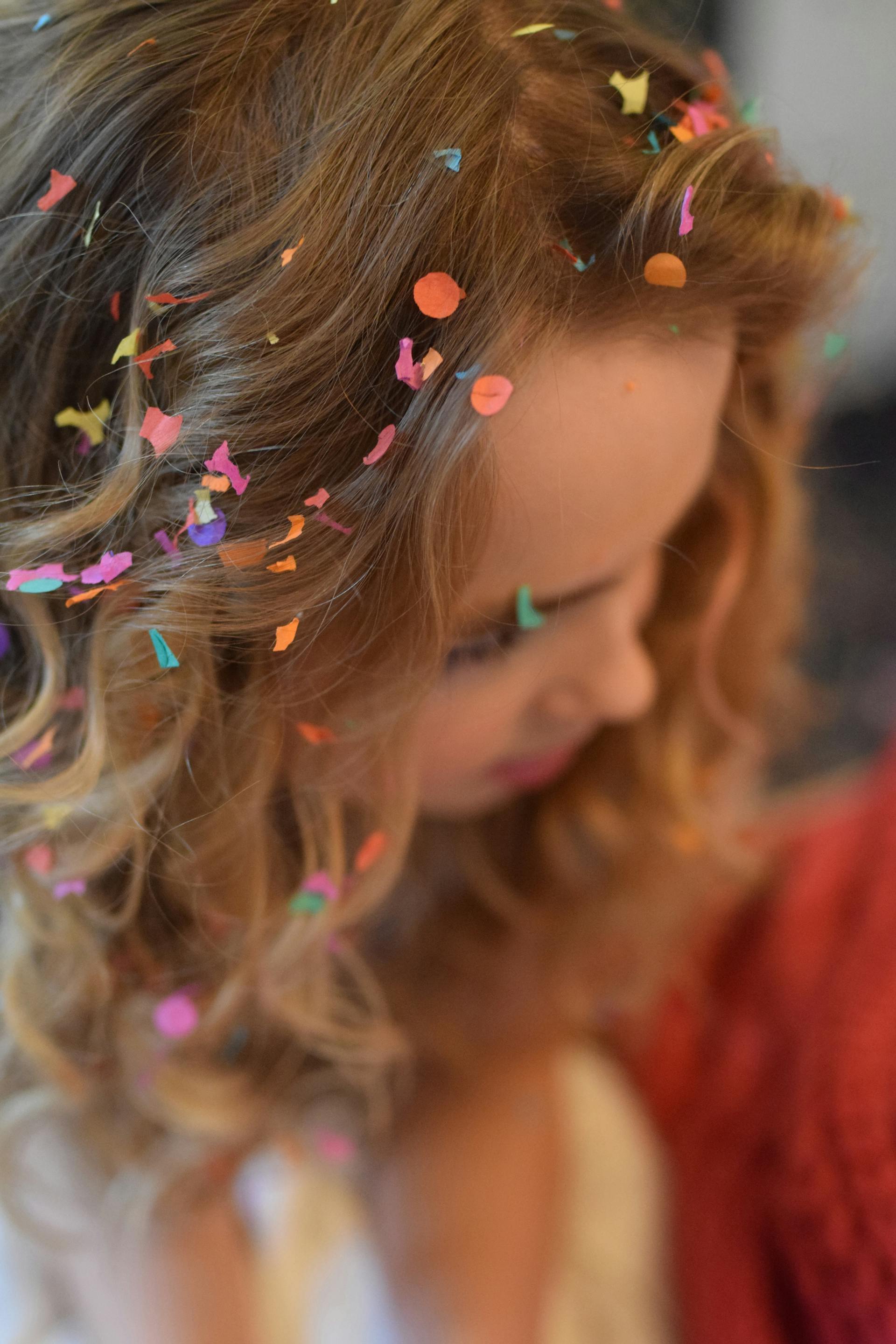 A brown-haired woman with confetti in her hair | Source: Pexels