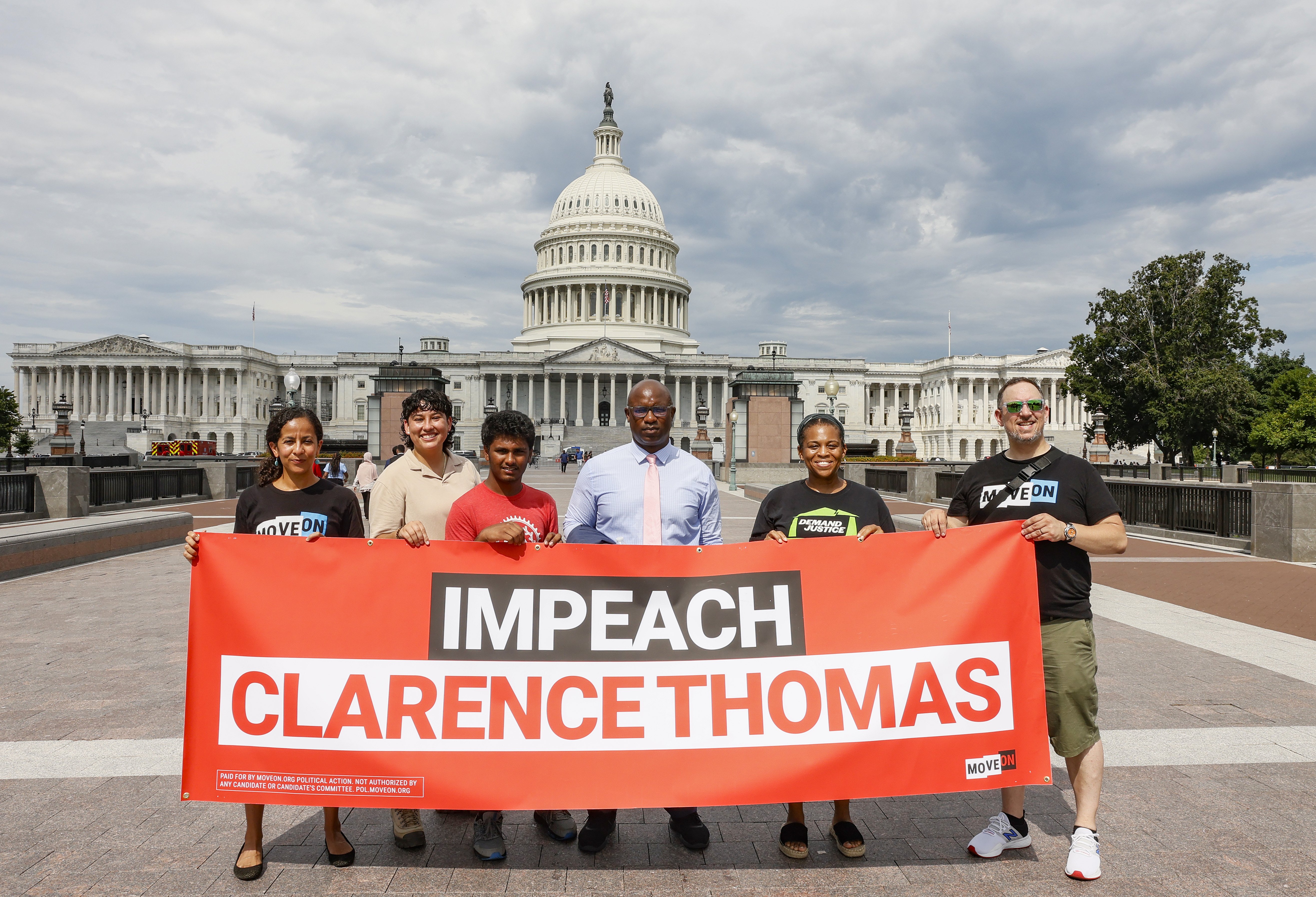 Rep. Jamaal Bowman, Tamara Brummer and Matthew Witten hold up an "Impeach Clarence Thomas" banner outside of the US Capitol after a demonstration in Washington, DC | Source: Getty Images