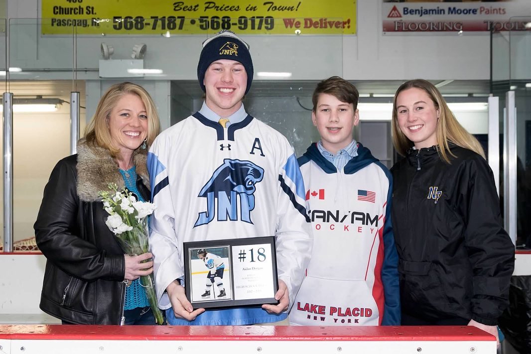 Aidan Dorgan stands on the ice with relatives during a hockey recognition event | Source: Instagram/adawg_18