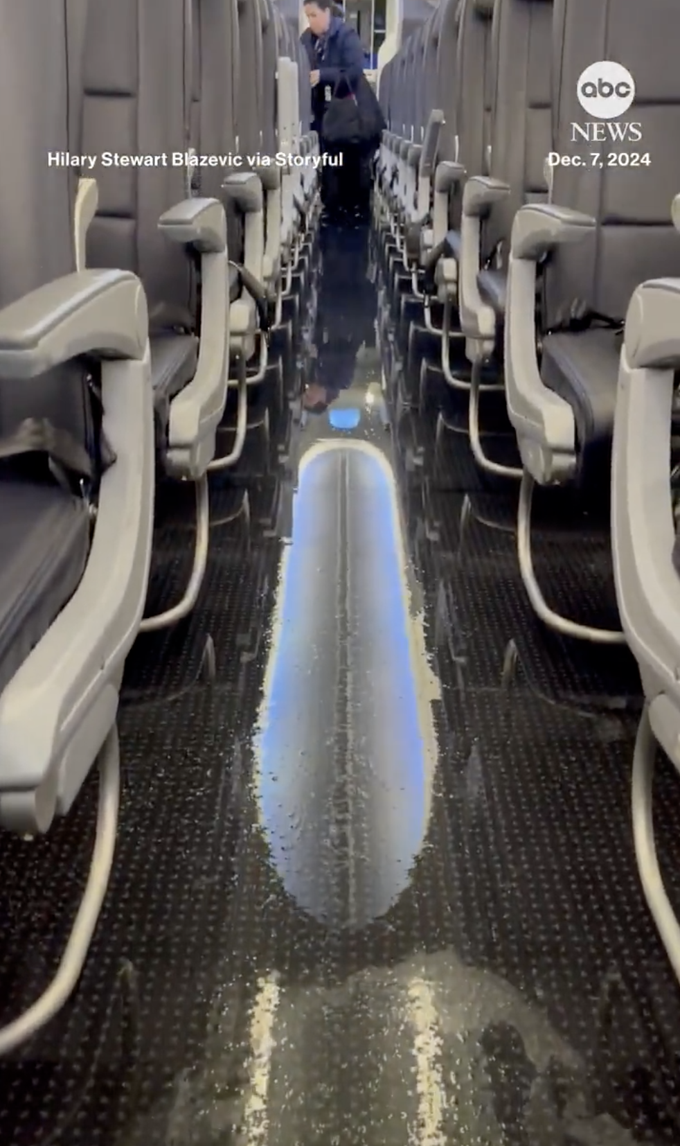 A passenger takes her belongings after water fills the aisle of an American Airlines plane, from a post dated December 15, 2024 | Source: X/ABC