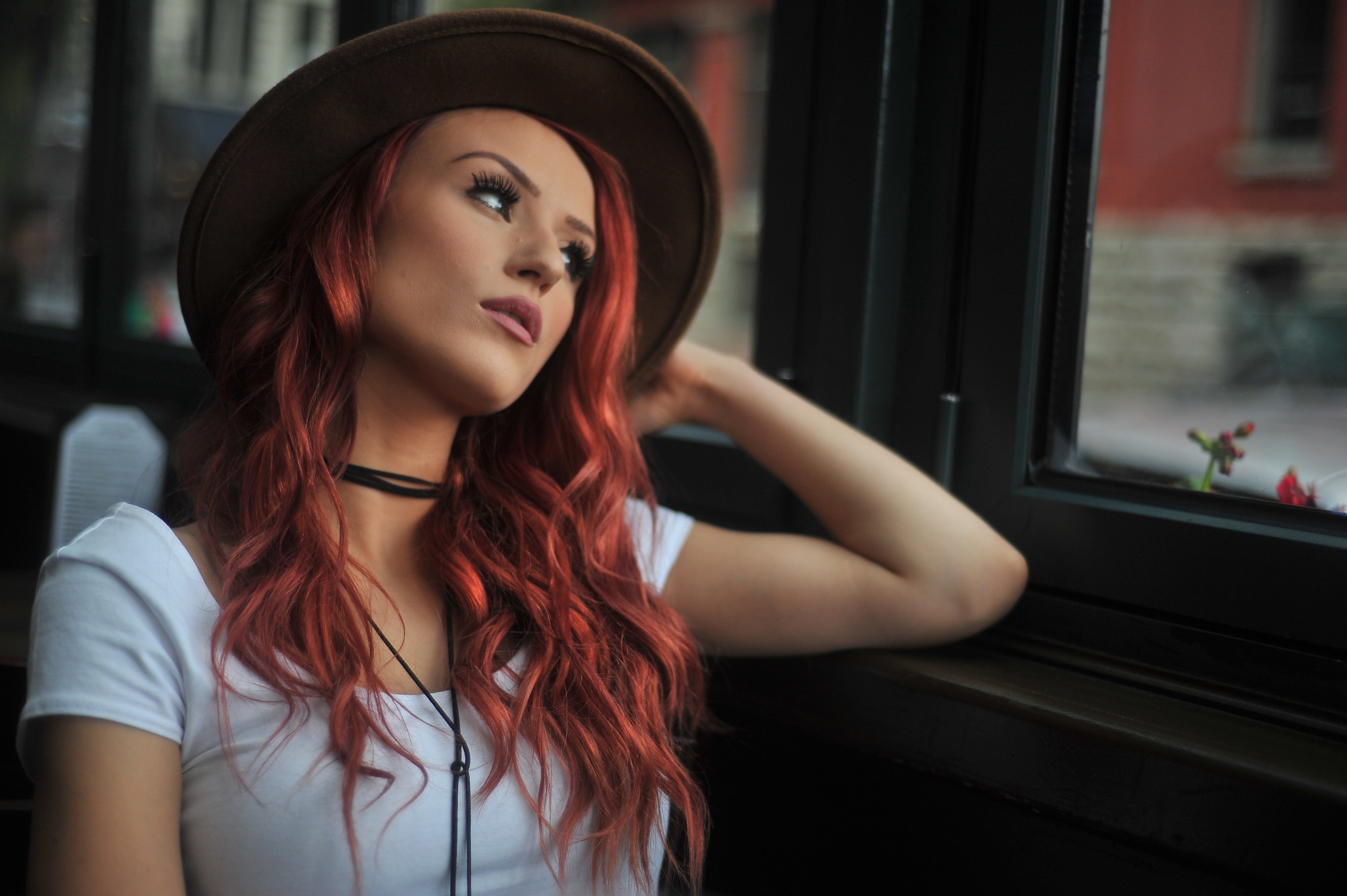 Redhead gazing wistfully out of the window. | Source: Pexels