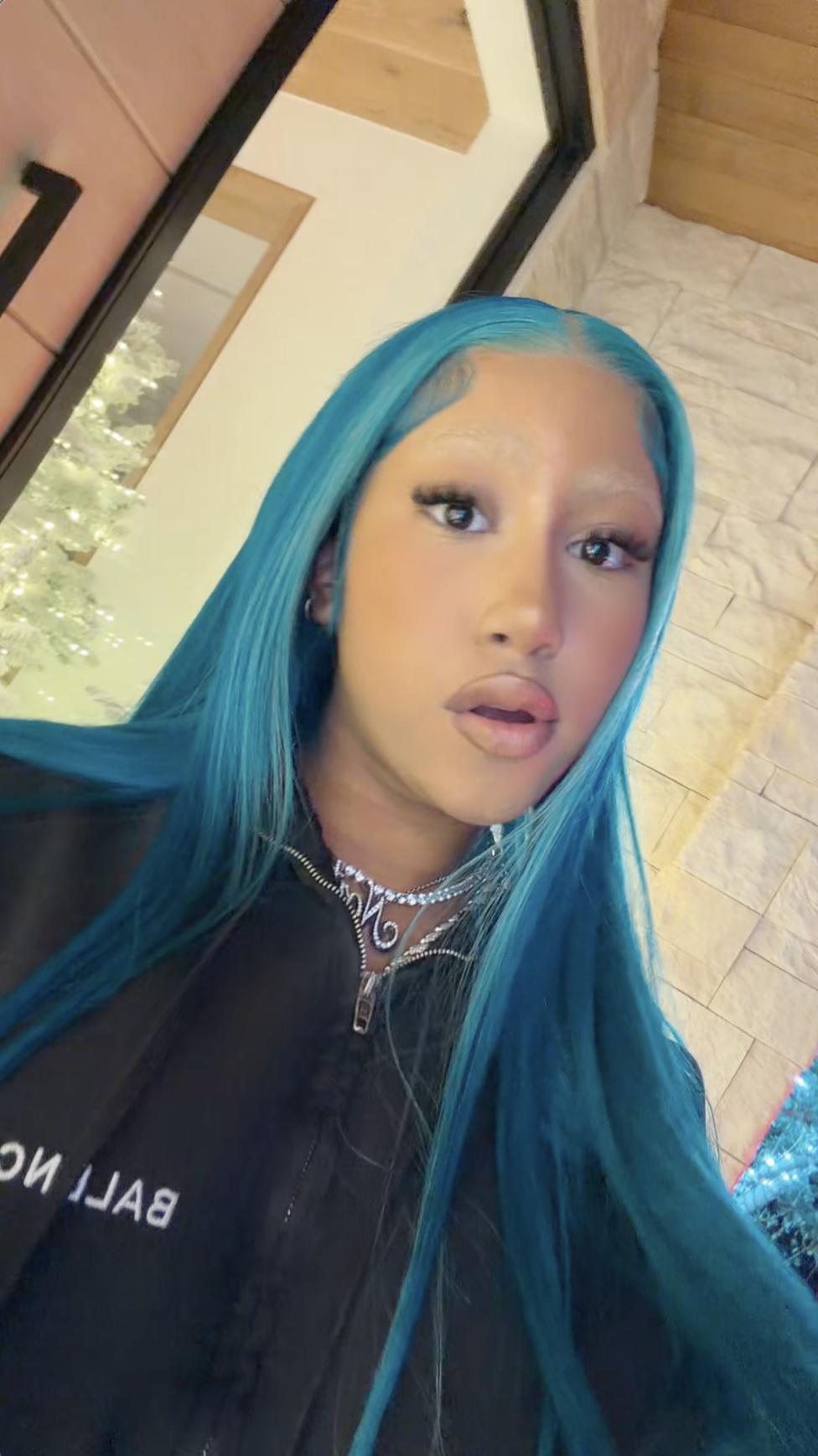 North West poses in front of a lit Christmas tree, wearing a black Balenciaga jacket and silver jewelry | Source: TikTok/kimandnorth