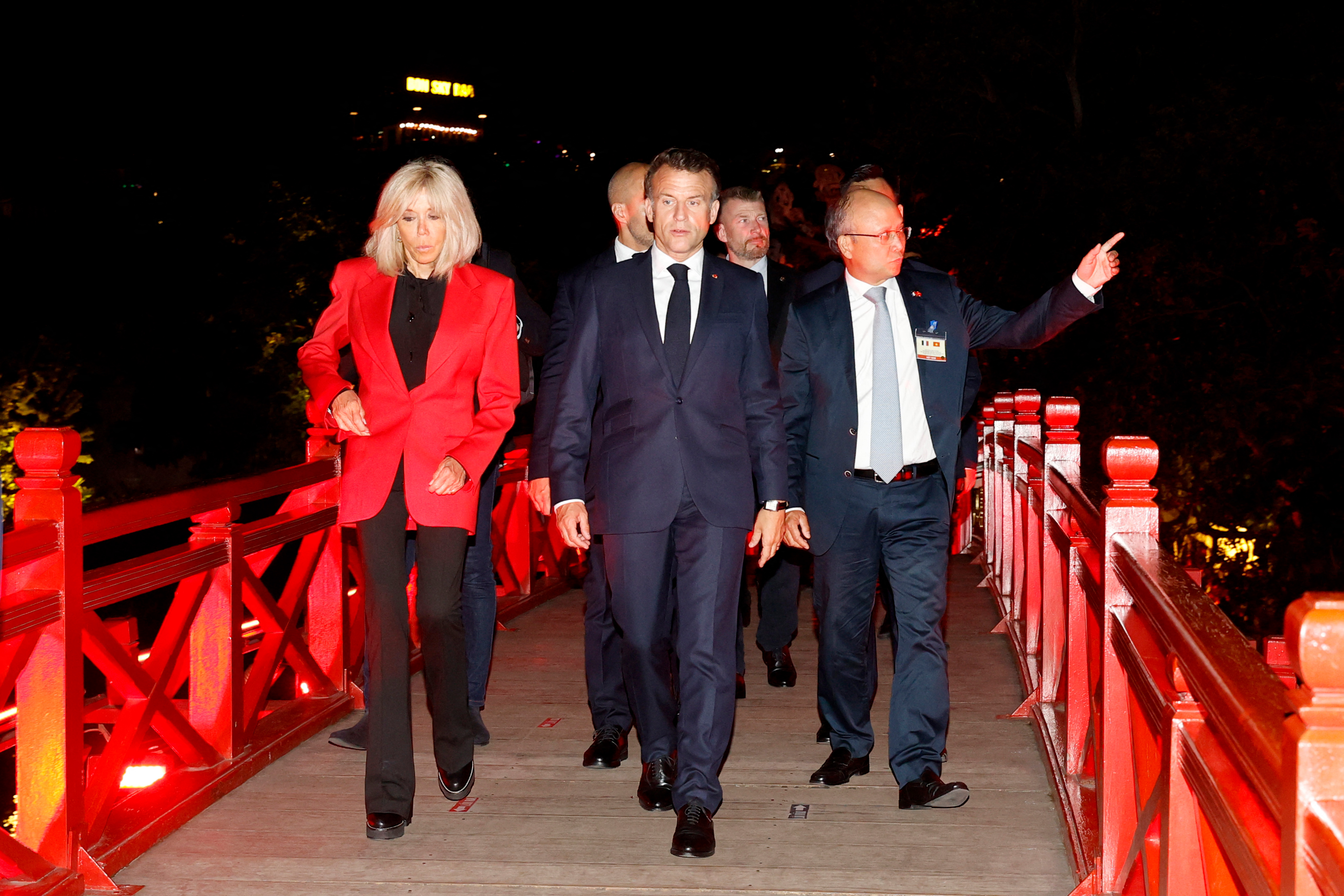 Brigitte and Emmanuel Macron walking on The Huc bridge at Hoan Kiem lake with an entourage in Hanoi, Vietnam. | Source: Getty Images