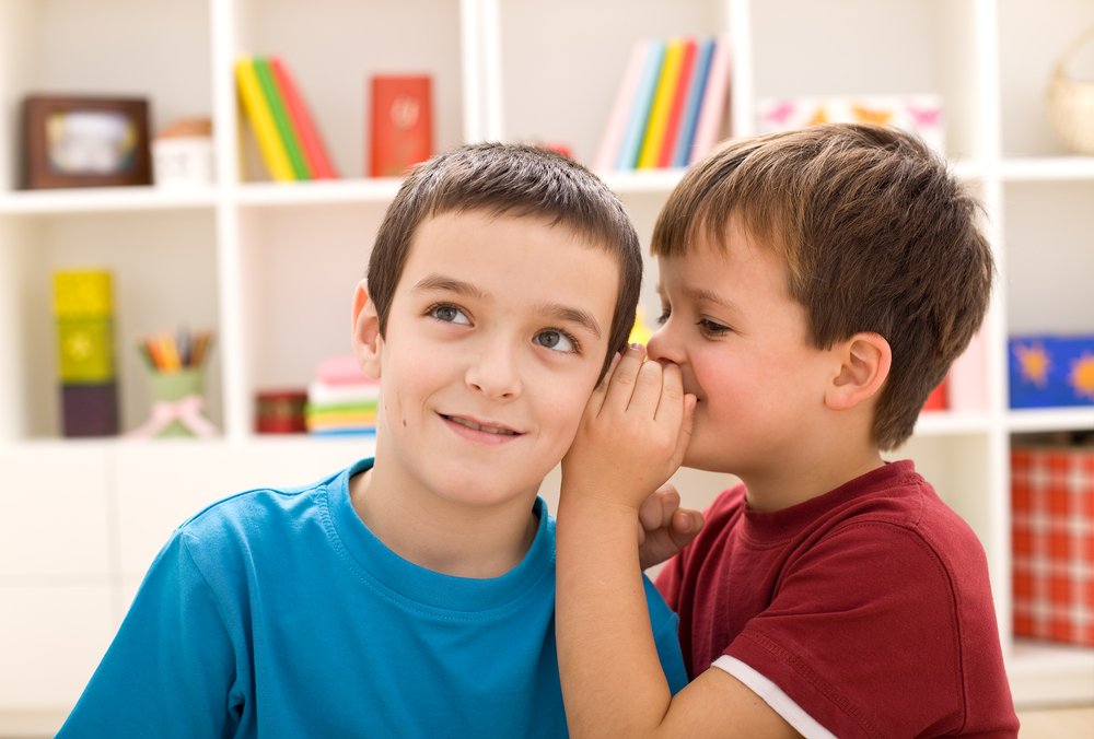 Dos niños diciéndose un secreto. | Foto: Shutterstock