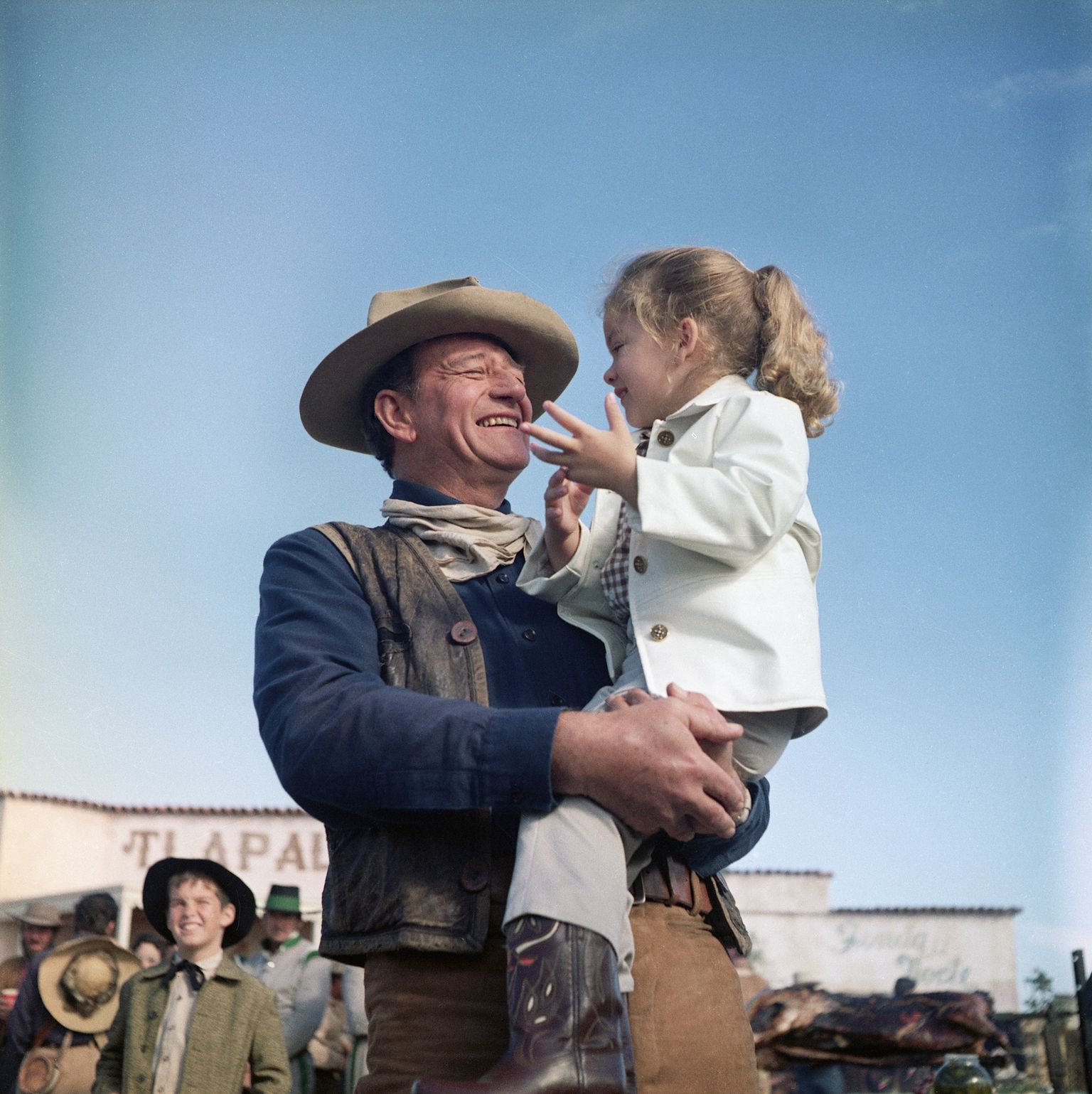 John Wayne holds his daughter, Aissa, on the set of "The Alamo." | Source: Getty Images