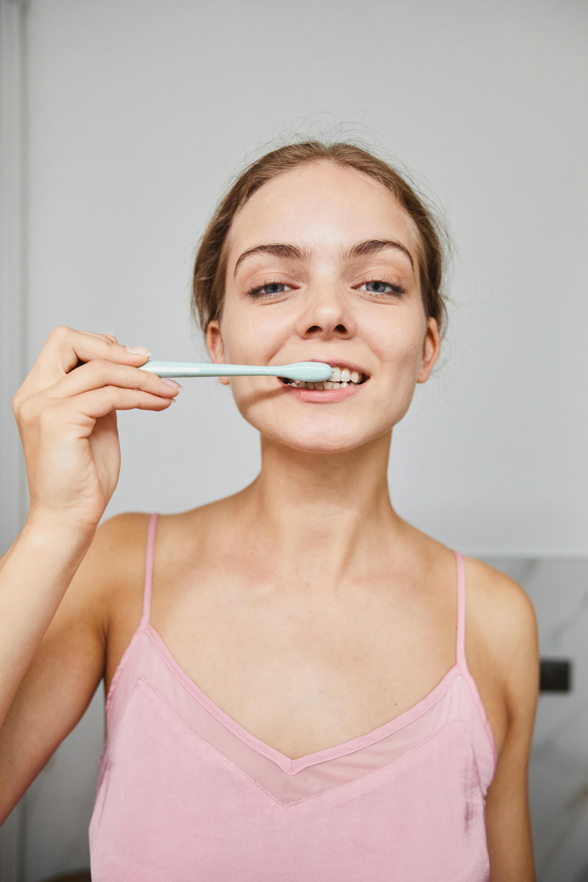 A woman brushing her teeth | Source: Pexels