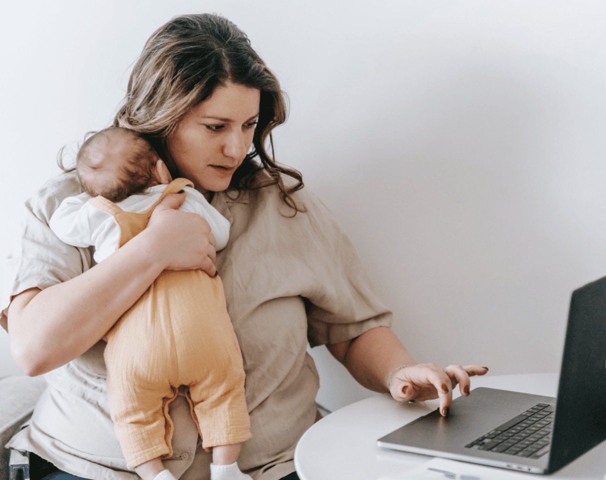 Berufstätige Mutter, die ihr Baby hält. | Quelle: Pexels