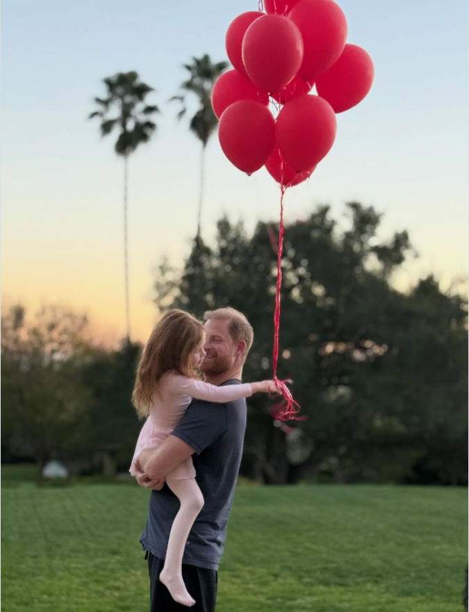 Prince Harry embraces Princess Lilibet beneath a cluster of bright red balloons as the pair share a sunset moment in an open field. | Source: Instagram/meghan