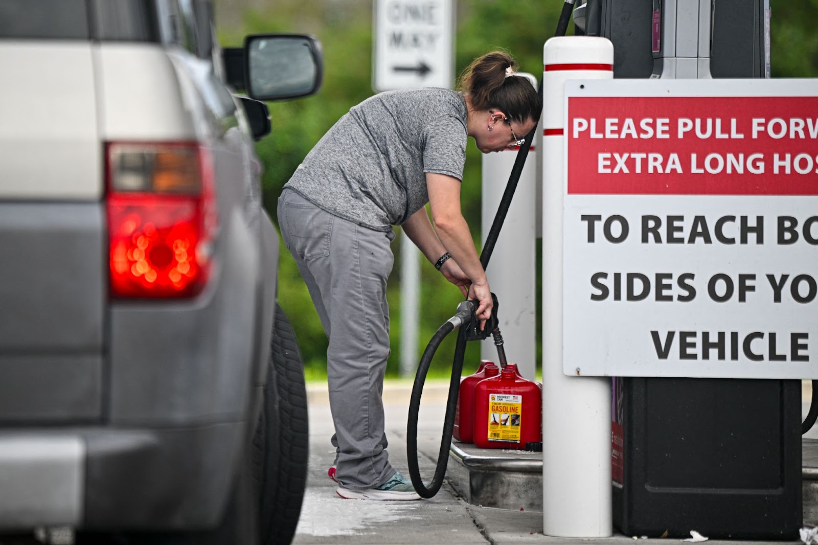 A woman filing up gas containers at a station ahead of Hurricane Milton's expected landfall in Lakeland, Florida. | Source: Getty Images