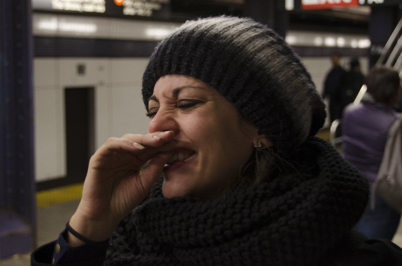 A woman laughing on the subway. | Photo: Flickr