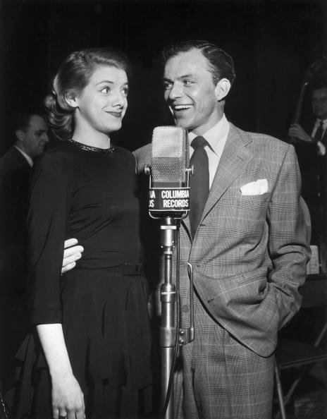 Rosemary Clooney and Frank Sinatra stand together in front of a Columbia Records microphone in this 1950 photo. | Source: Getty Images.