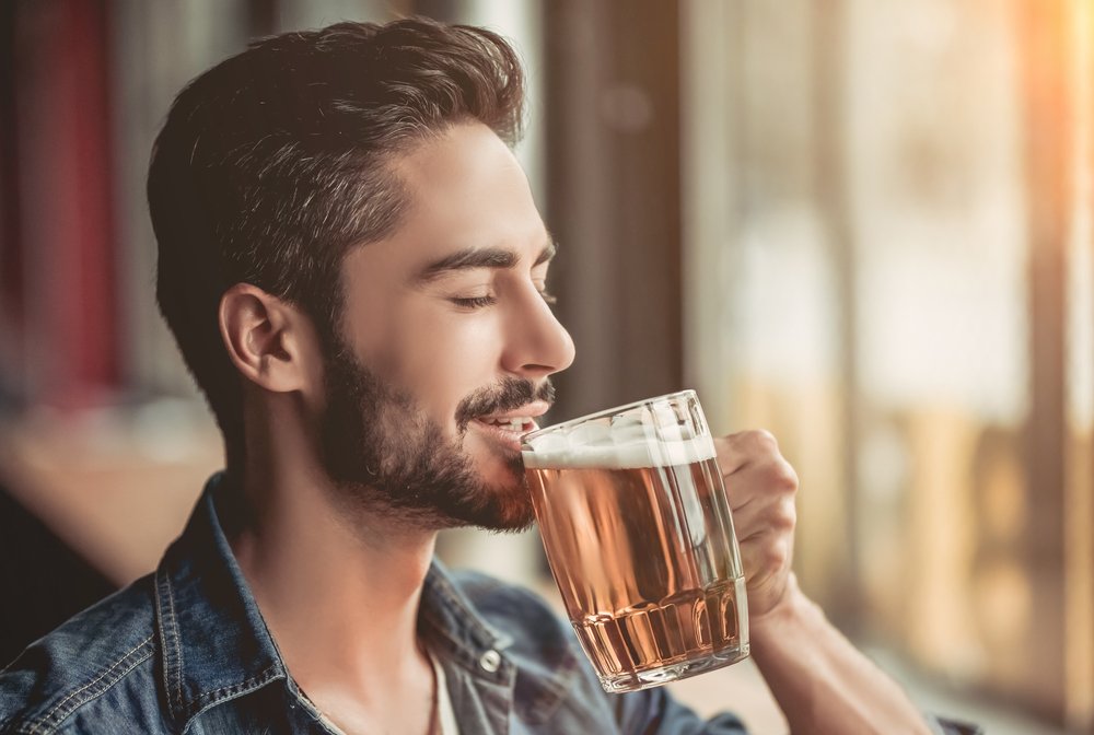 A young man drinking beer in the pub. | Photo: Shutterstock.