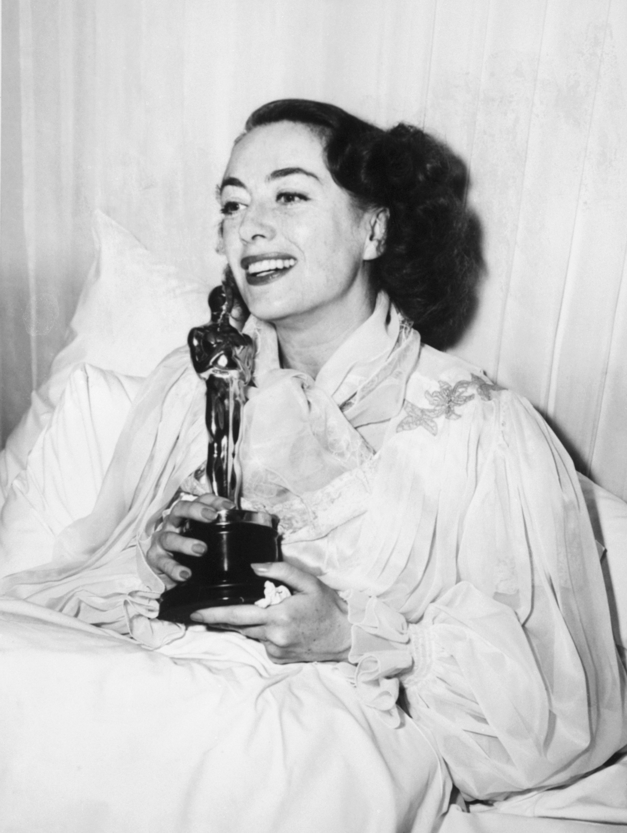 Hollywood starlet Joan Crawford smiling while holding her Academy Award on March 9 in 1946. / Source: Getty Images