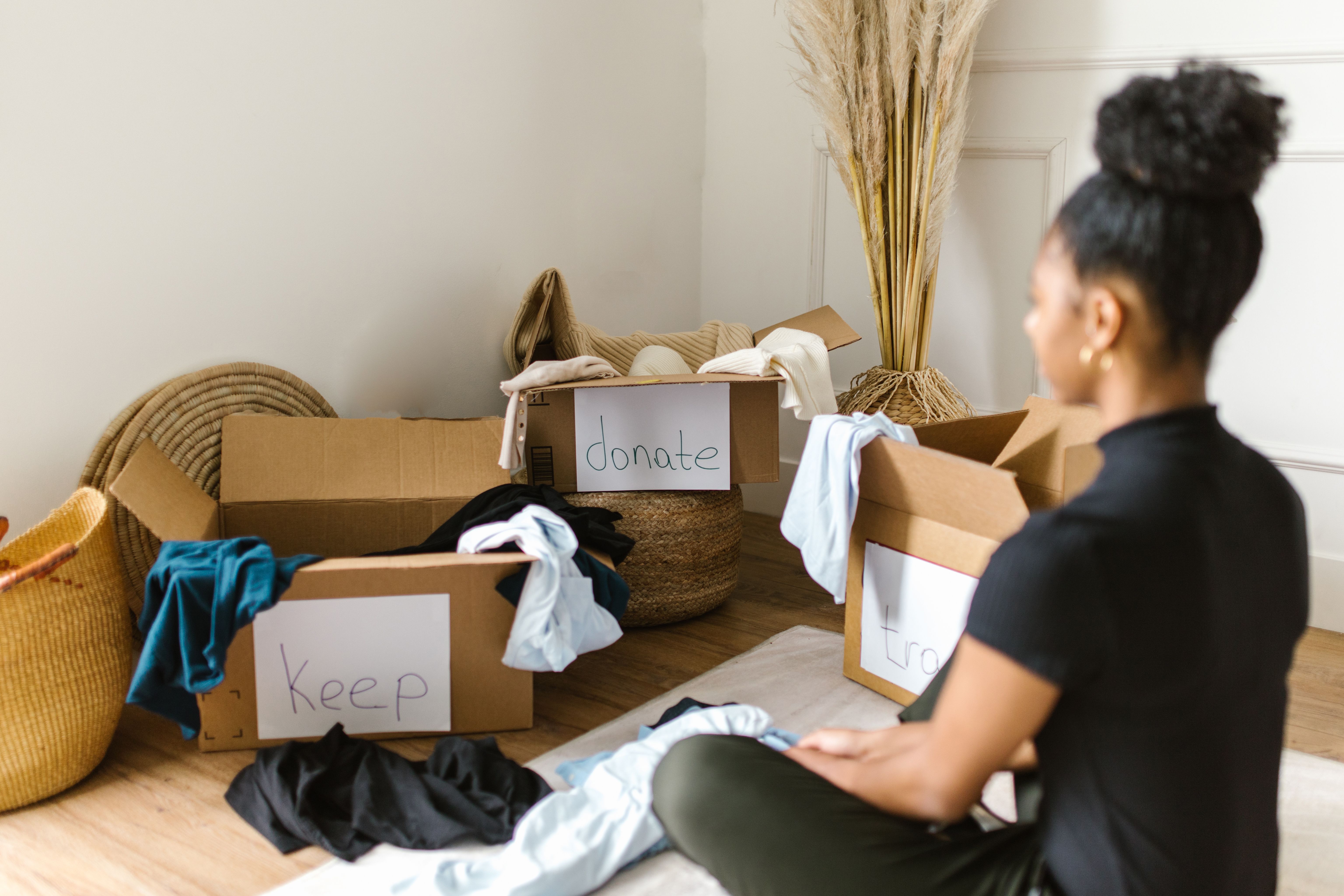 A woman staring at boxes for decluttering | Source: Pexels