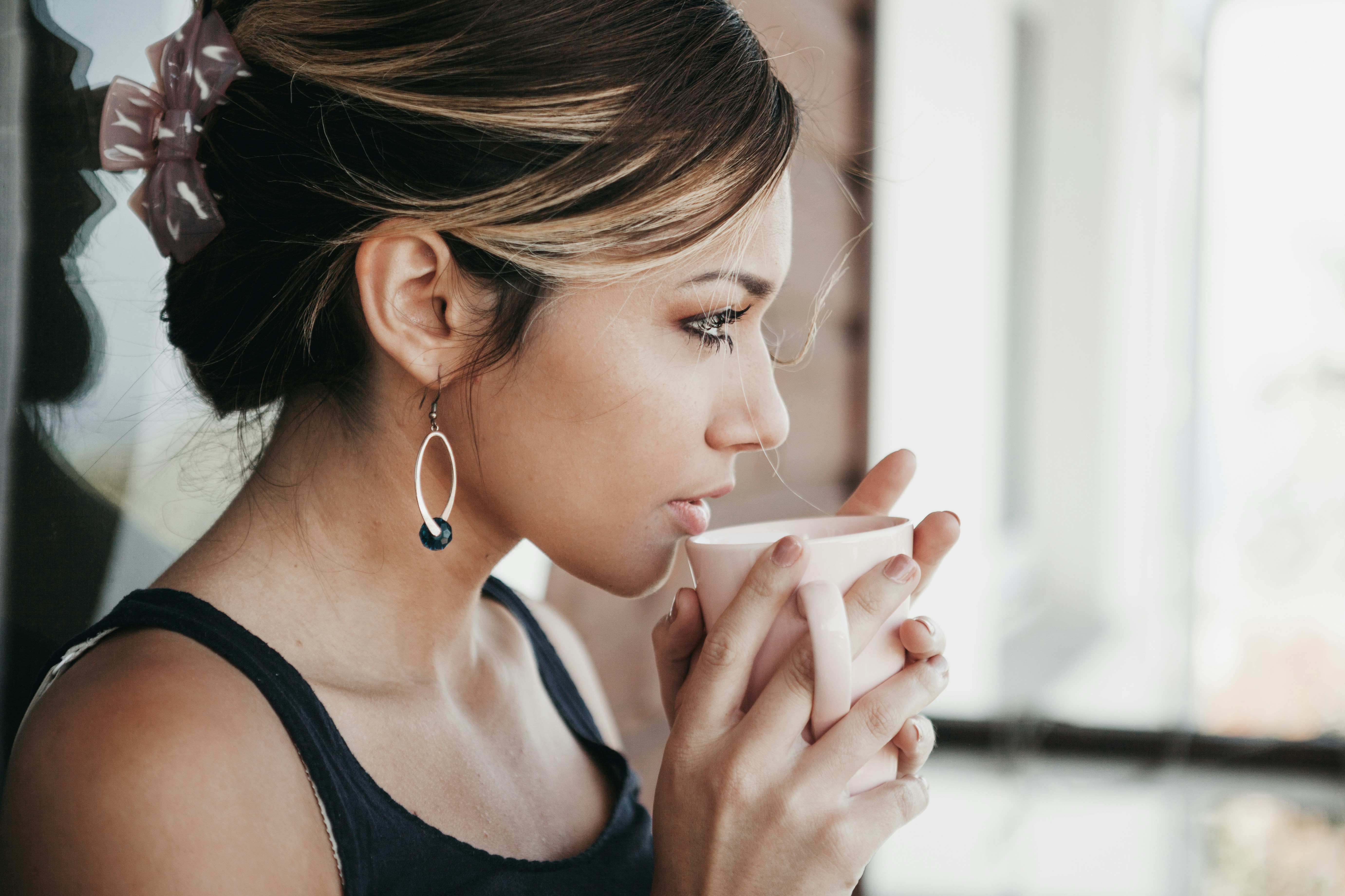 A woman drinking from a cup | Source: Unsplash