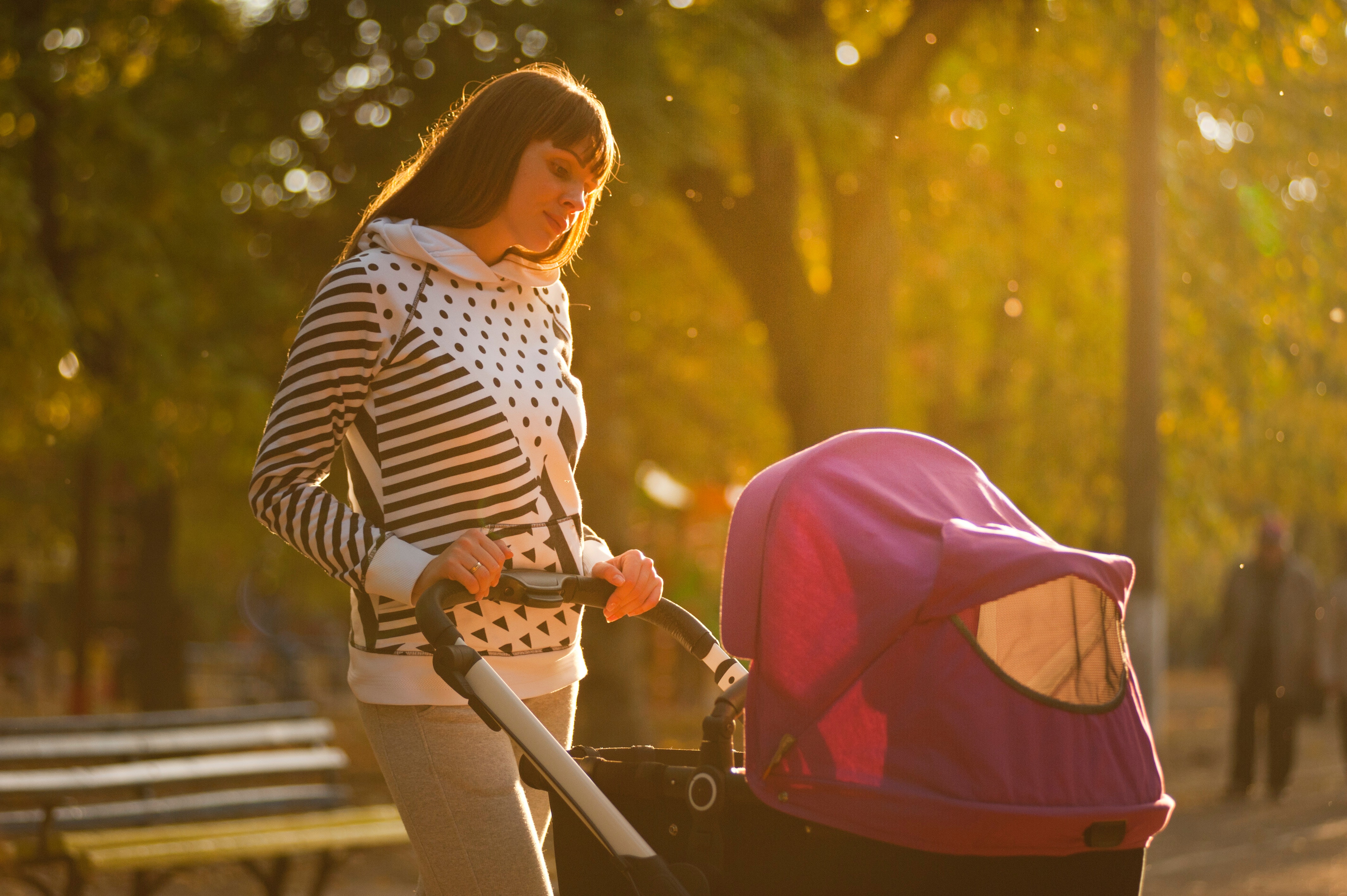 A woman pushing a baby stroller at the park | Source: Pexels
