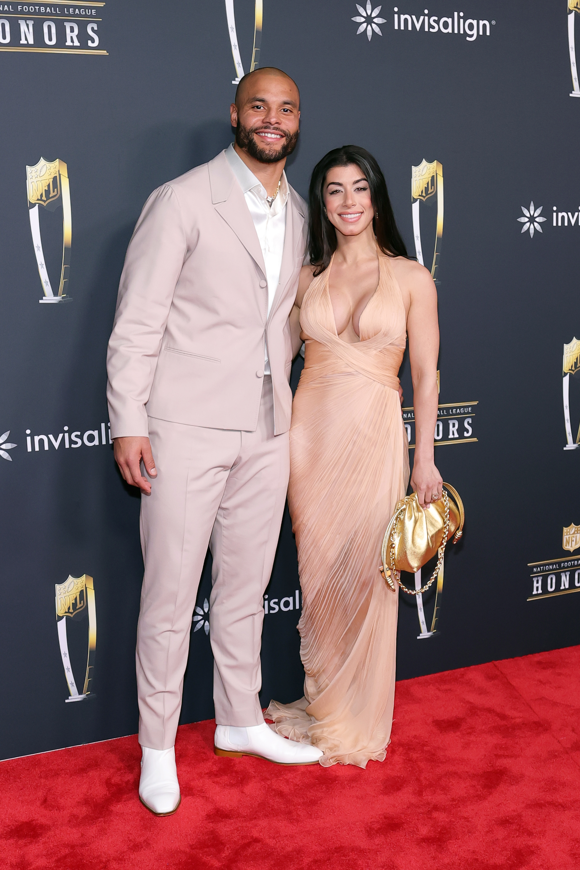 Dak Prescott and Sarah Jane Ramos pose together in coordinated neutral looks, the quarterback smiling beside Sarah as they present a united and elegant appearance.