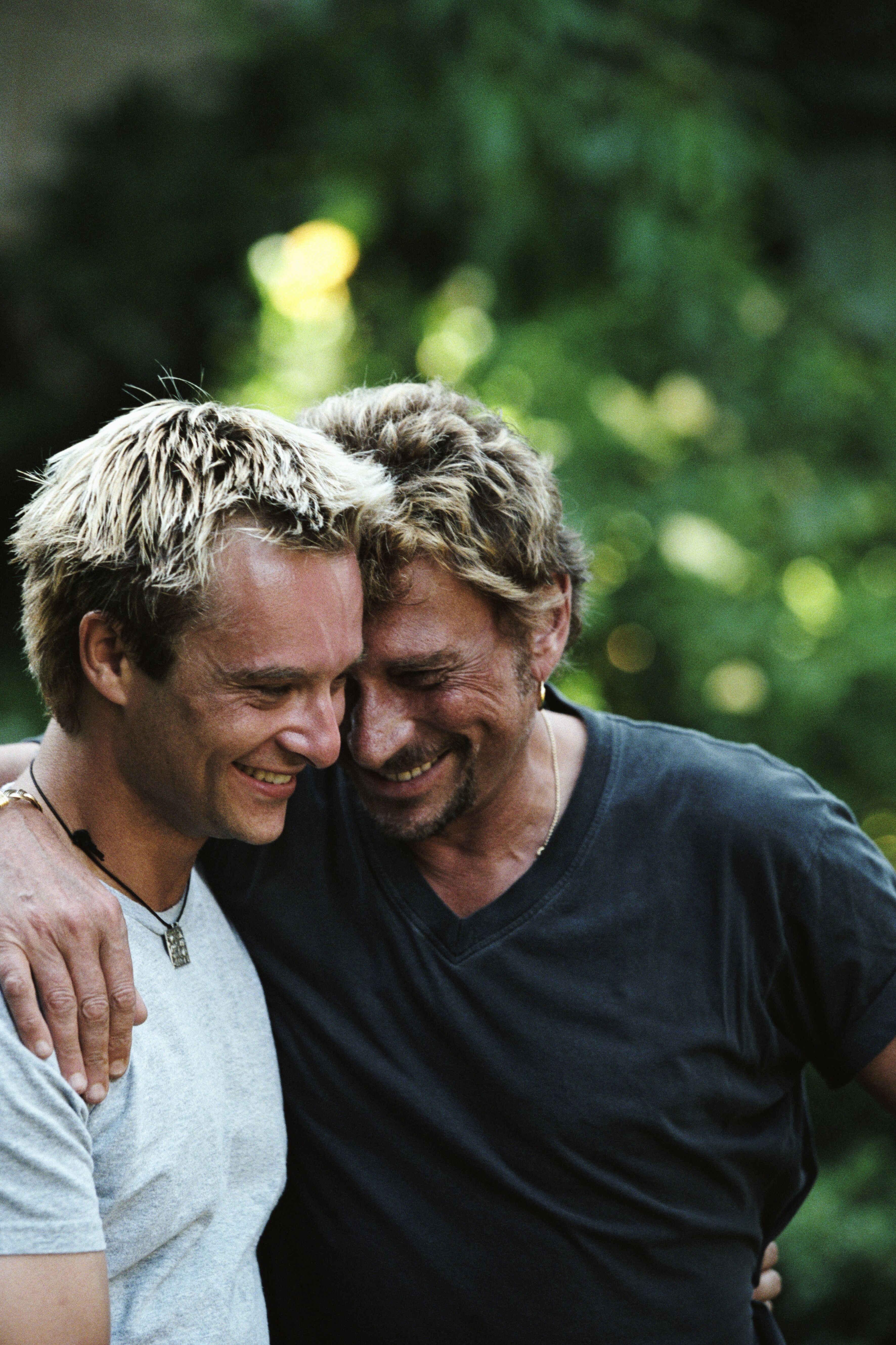Johnny Hallyday et son fils David Hallyday échangent un moment complice | Photo : Getty Images.