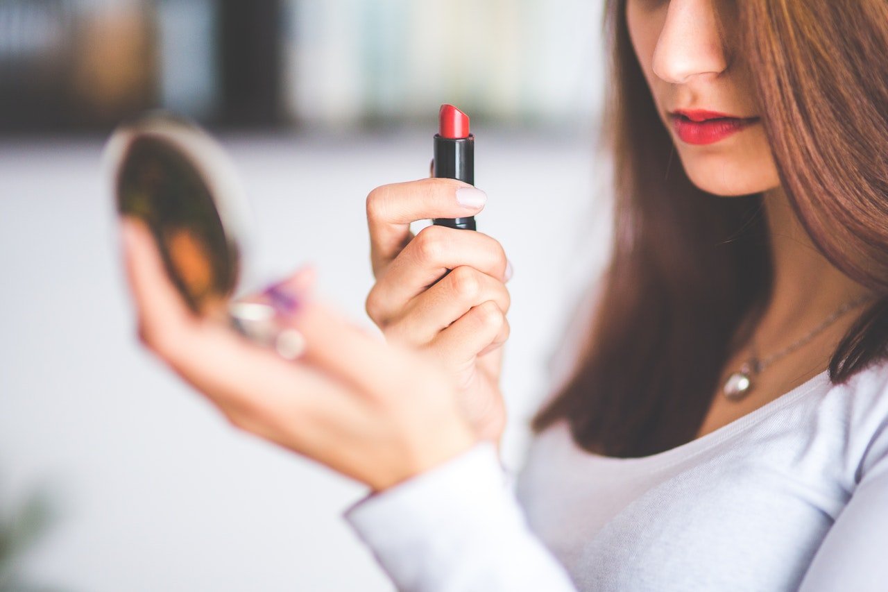 Mujer pintando sus labios.| Foto: Pexels