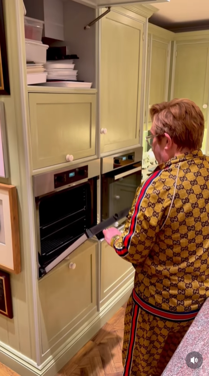 Even the oven joins the mutiny — bursting into "Step Into Christmas" the moment John pulls the door open. At this point, he's not cooking dinner; he's fighting for festive survival. | Source: Instagram/eltonjohn