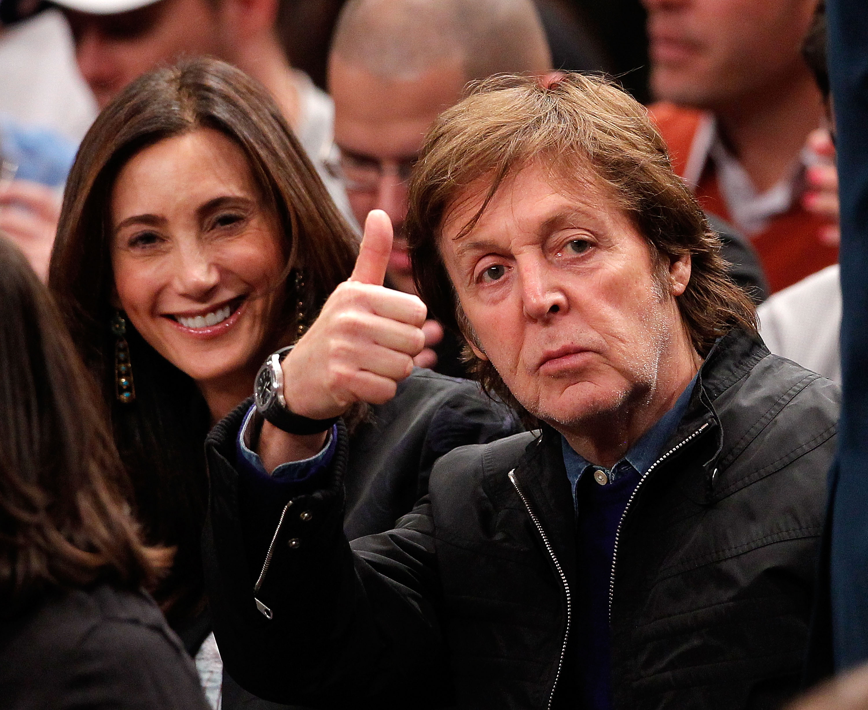 Paul McCartney gives a thumbs up to fans as his wife Nancy Shevell smiles during an NBA basketball game at Madison Square Garden in New York City, on February 17, 2012. | Source: Getty Images