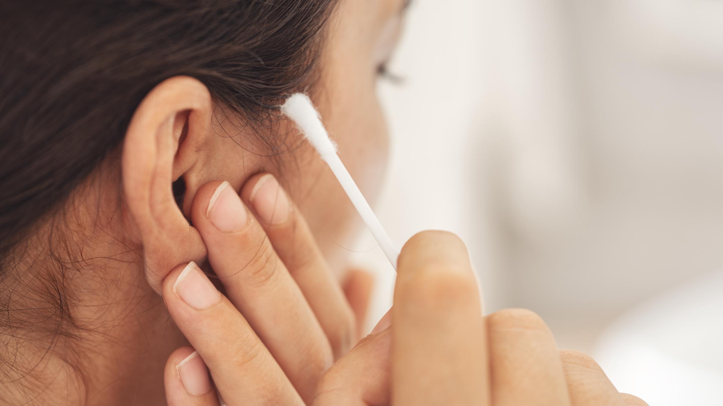 A woman cleaning her ears with a Q-tip | Source: Getty Images