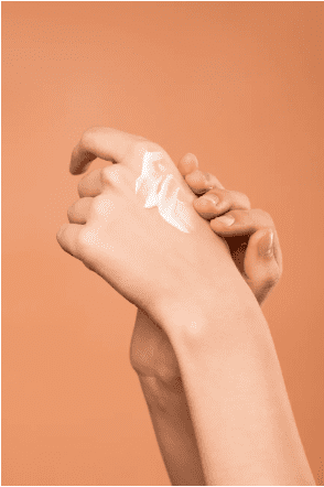 Femme appliquant une crème pour les mains. | Photo : Pexels