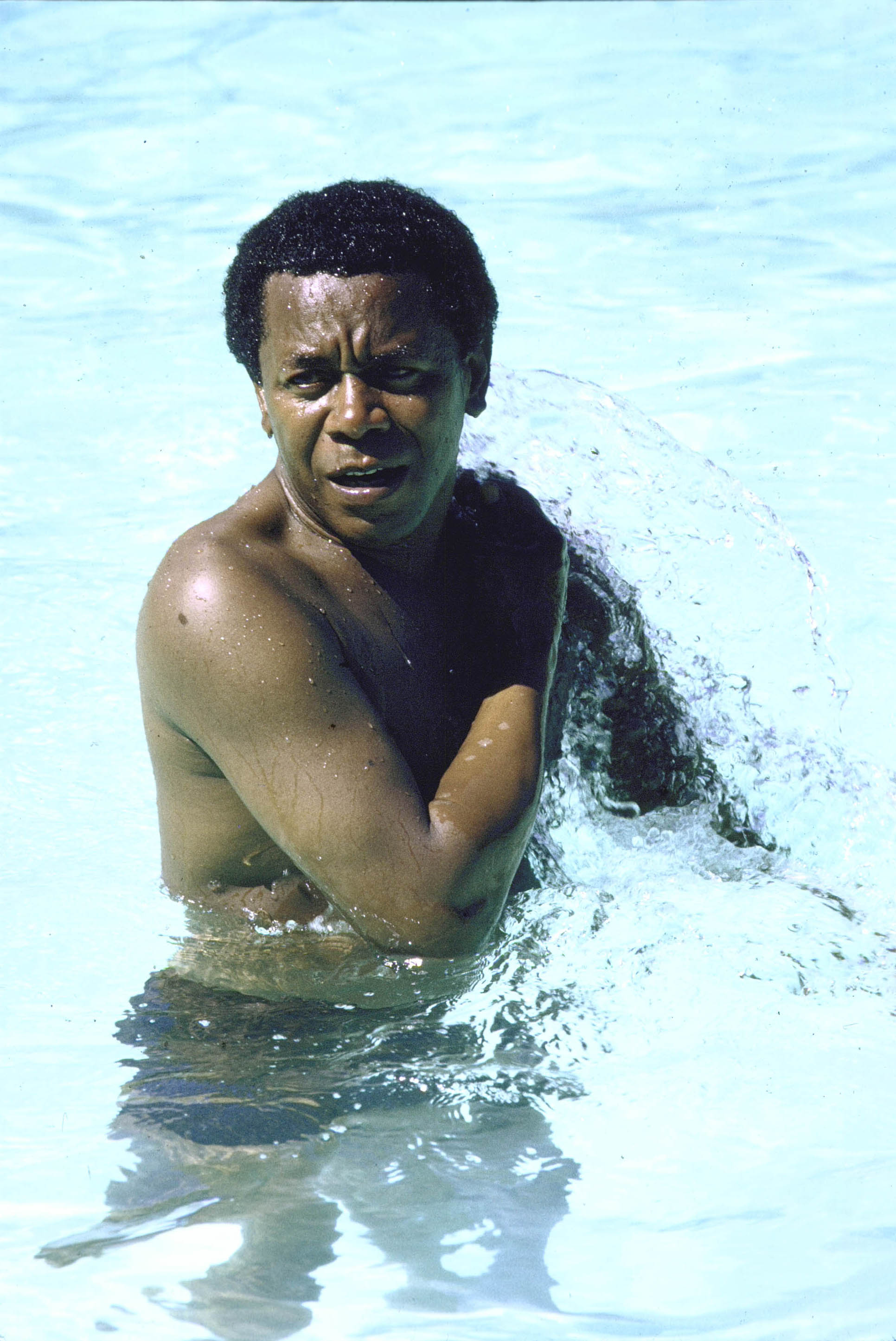 Flip Wilson cooling off in a motel pool during cross-country car trip | Photo: Getty Images