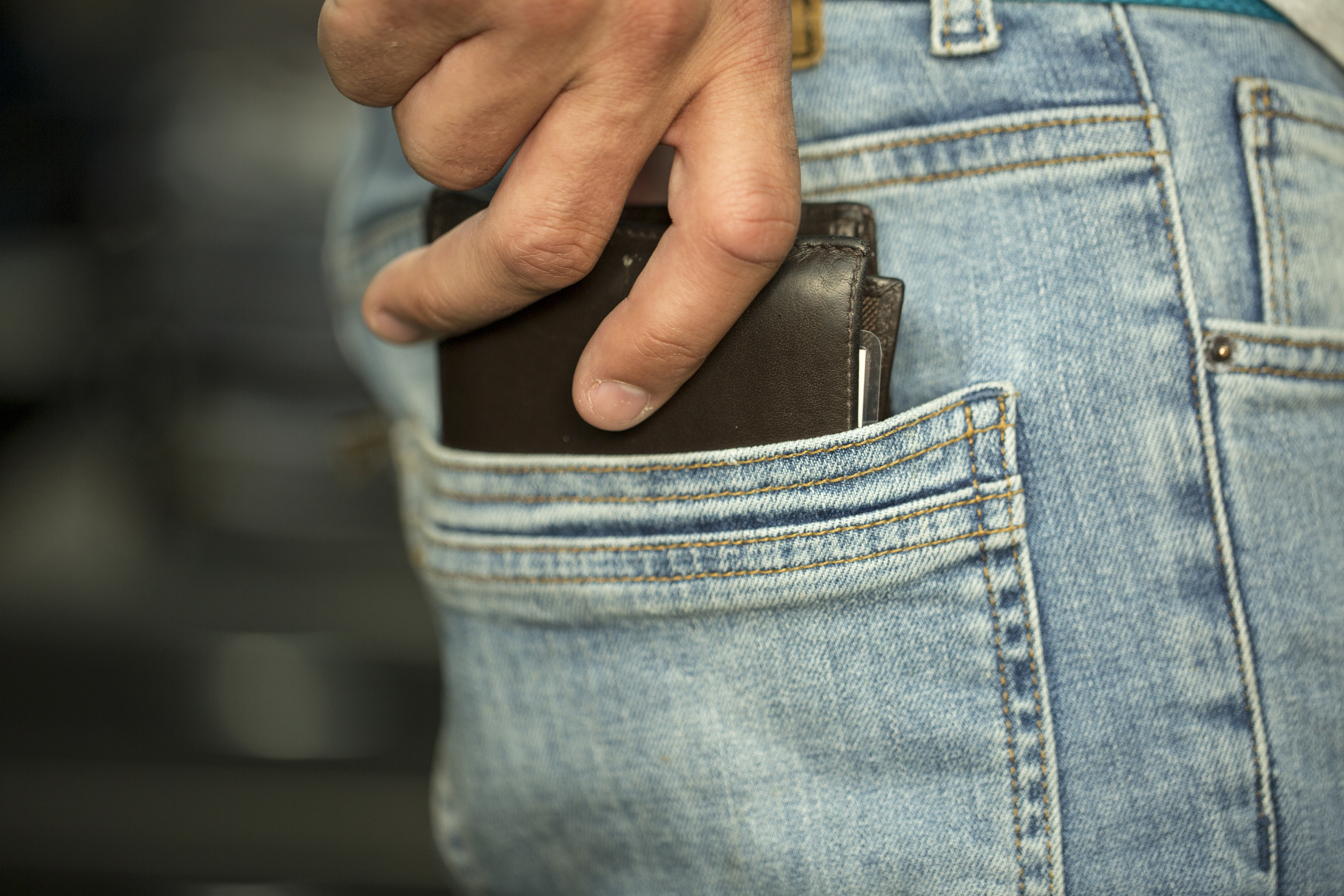 A man taking his wallet and putting it in his back pocket | Source: Shutterstock