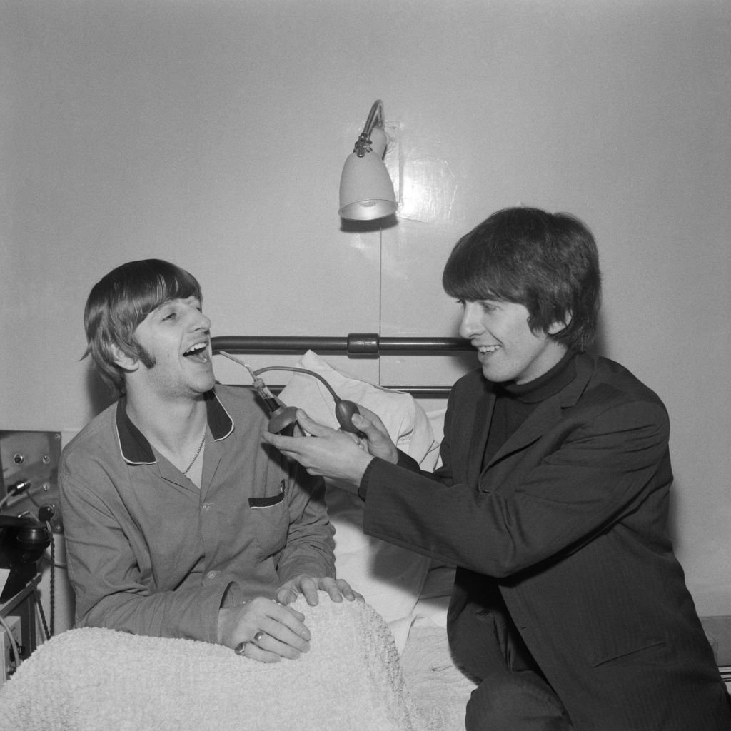 Ringo Starr gets a visit from fellow Beatle George Harrison (1943 - 2001) whilst recuperating from an operation to remove his tonsils | Getty Images / Global Images Ukraine Ringo Starr gets a visit from fellow Beatle George Harrison (1943 - 2001) whilst recuperating from an operation to remove his tonsils | Getty Images / Global Images Ukraine