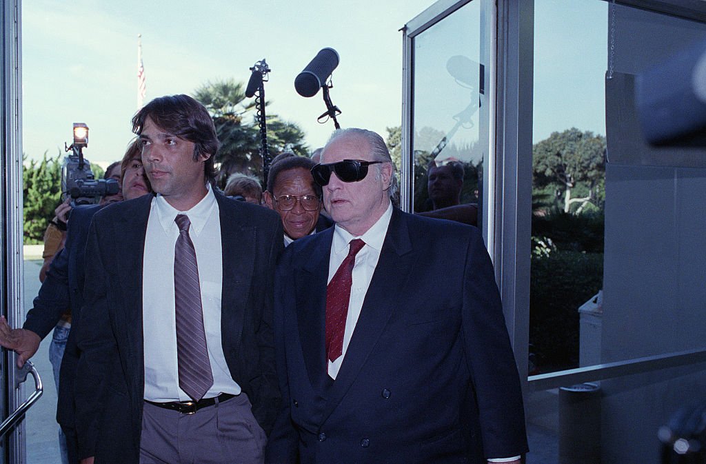 Der Schauspieler Marlon Brando begleitet seinen Sohn Christian zu einer Anhörung vor dem Superior Court wegen der Anklage, Christian Brando habe die Geliebte seiner Halbschwester am 26. September 1990 ermordet. | Quelle: Getty Images