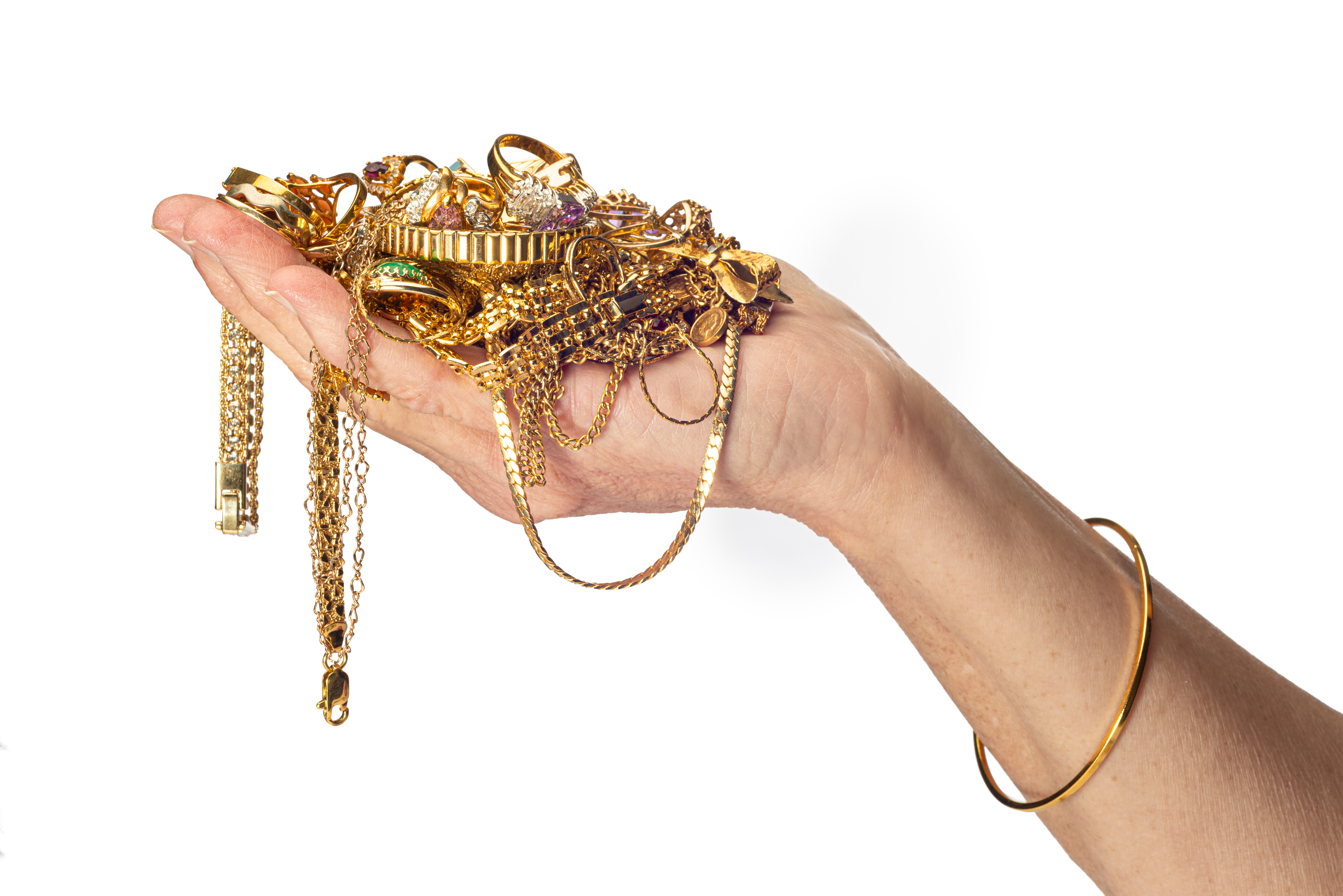 A hand holding gold jewelry | Source: Shutterstock