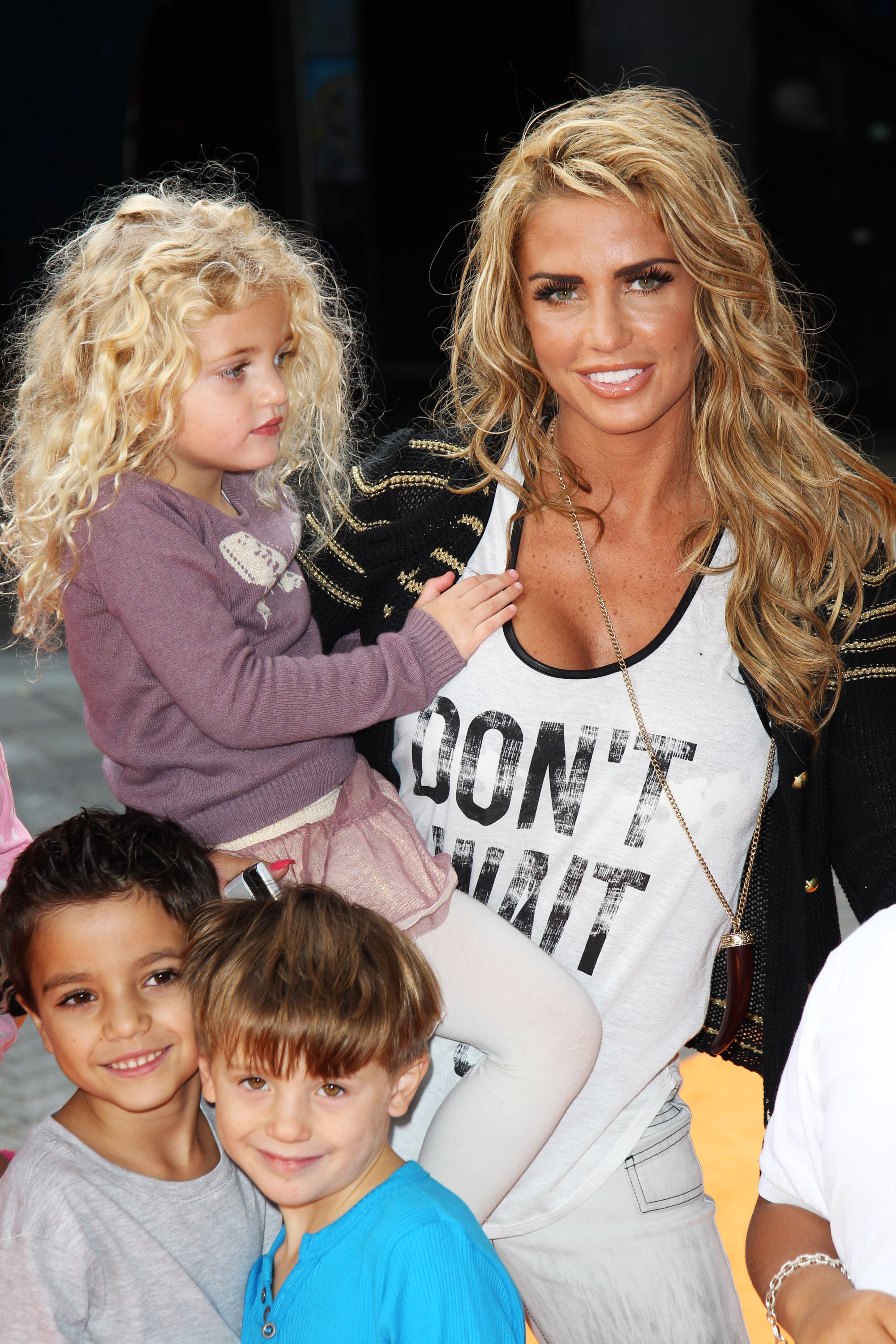 Katie Price posed with her children at the UK premiere of "The Lion King 3D" in London on September 25, 2011. Dressed down in a slogan tank and jeans, she beamed beside her daughter, who perched on her hip in a tutu, while her sons stood close — the family appearance offering a glimpse into her life away from headlines and glamour.