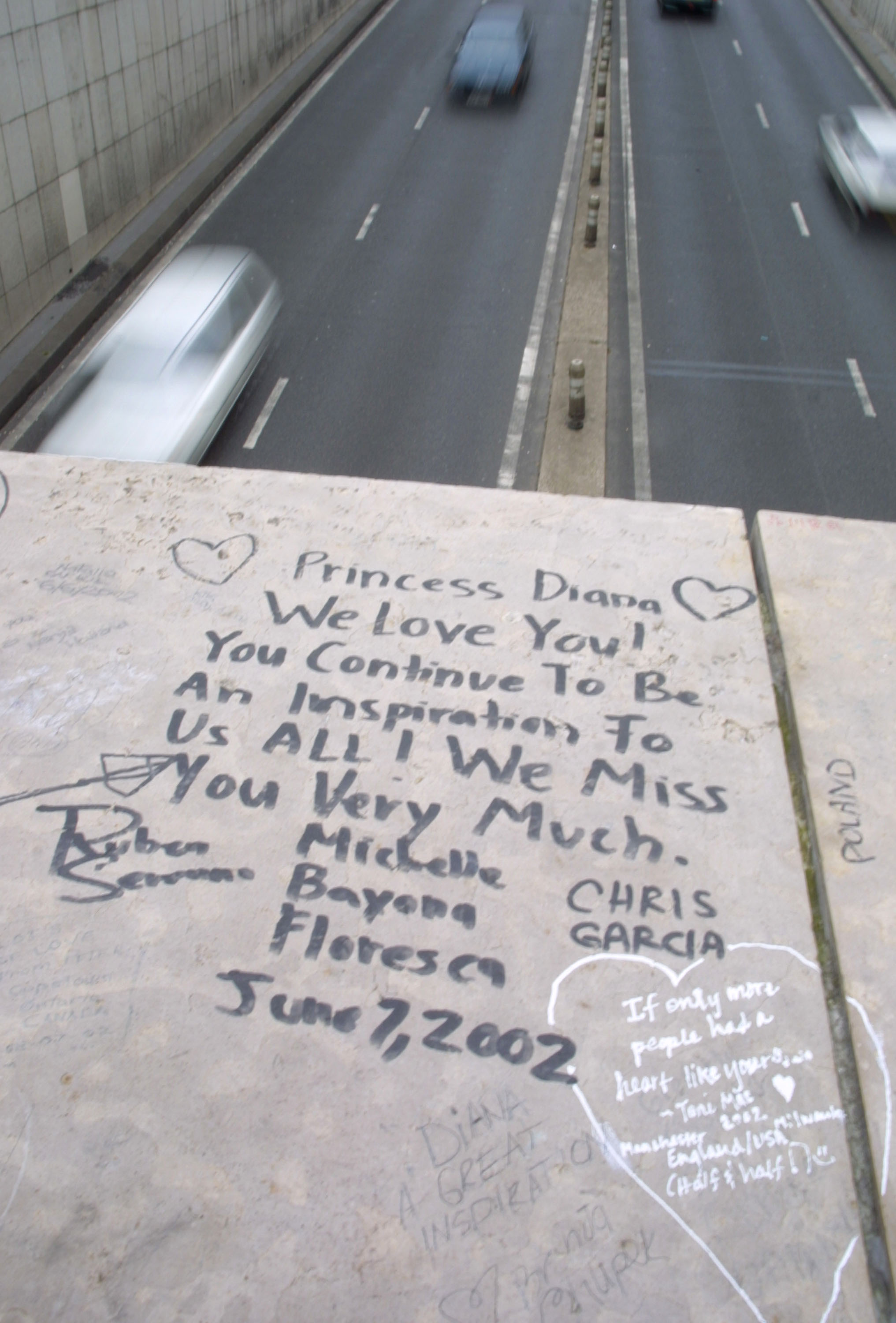 A fan pays tribute to the late Princess Diana of Wales with a note left near the crash site on the fifth anniversary of her death on August 30, 2002 in Paris, France | Source: Getty Images