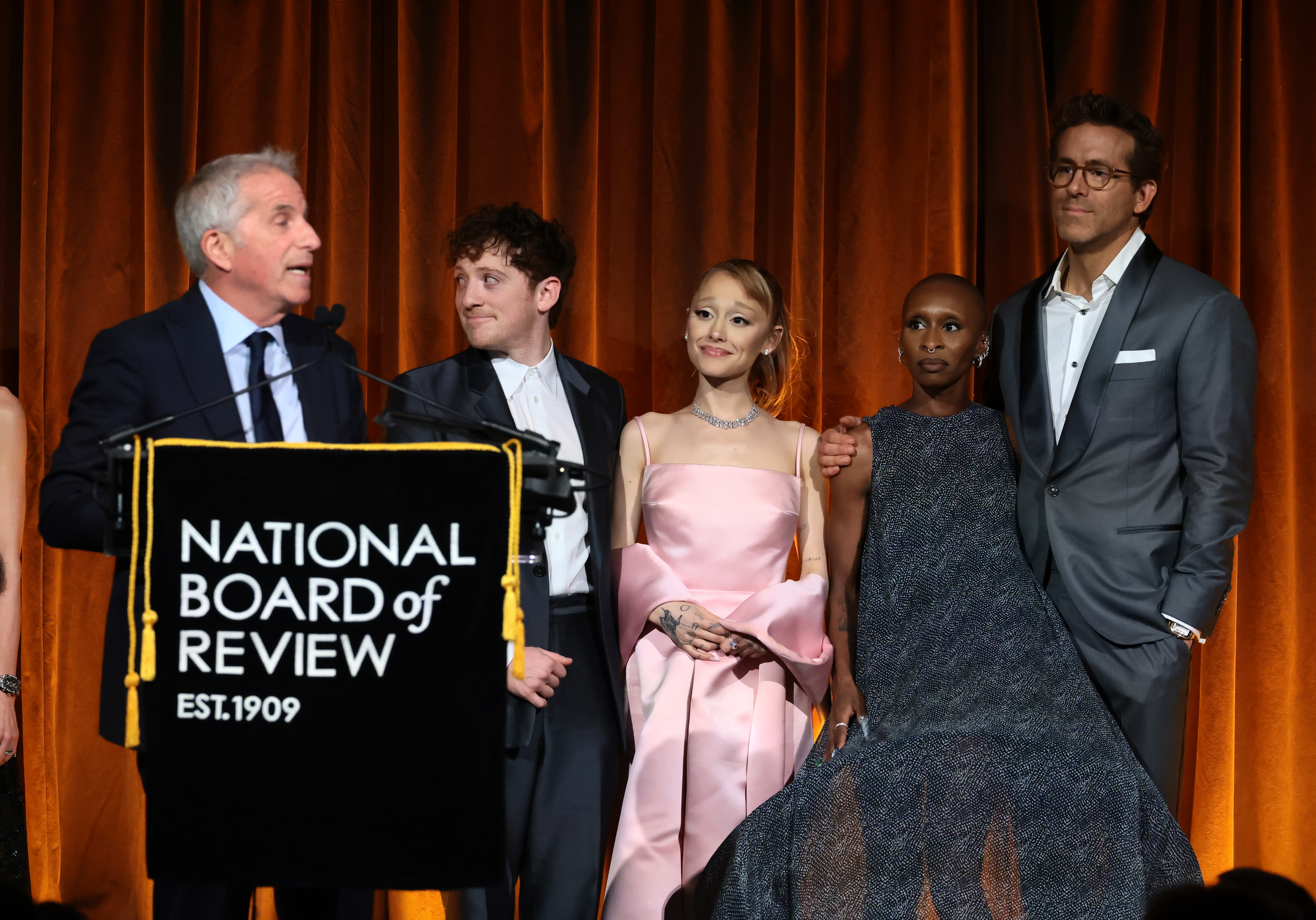 Marc Platt, Ethan Slater, Ariana Grande, and Cynthia Erivo accept the Best Film Award for "Wicked" from Ryan Reynolds onstage during The National Board of Review Annual Awards Gala | Source: Getty Images