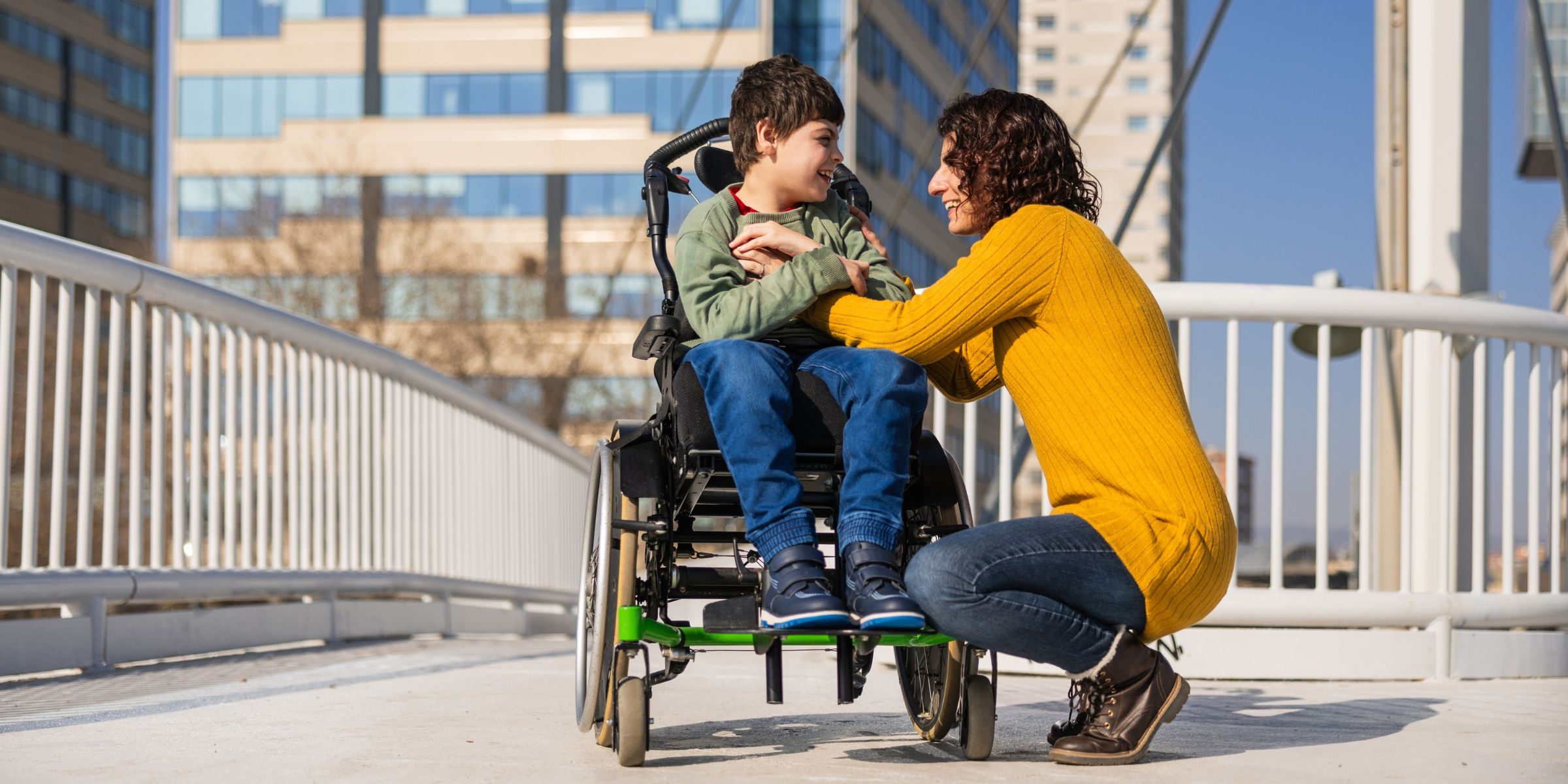 A woman sitting beside her son in a wheelchair | Source: Shutterstock