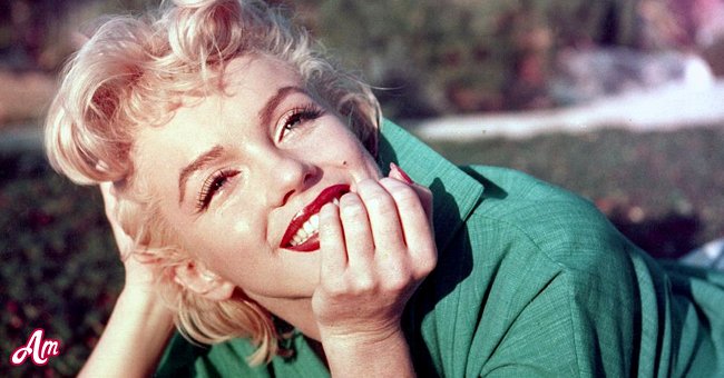 Actress Marilyn Monroe poses for a portrait laying on the grass in 1954 in Palm Springs, California. | Source: Getty Images