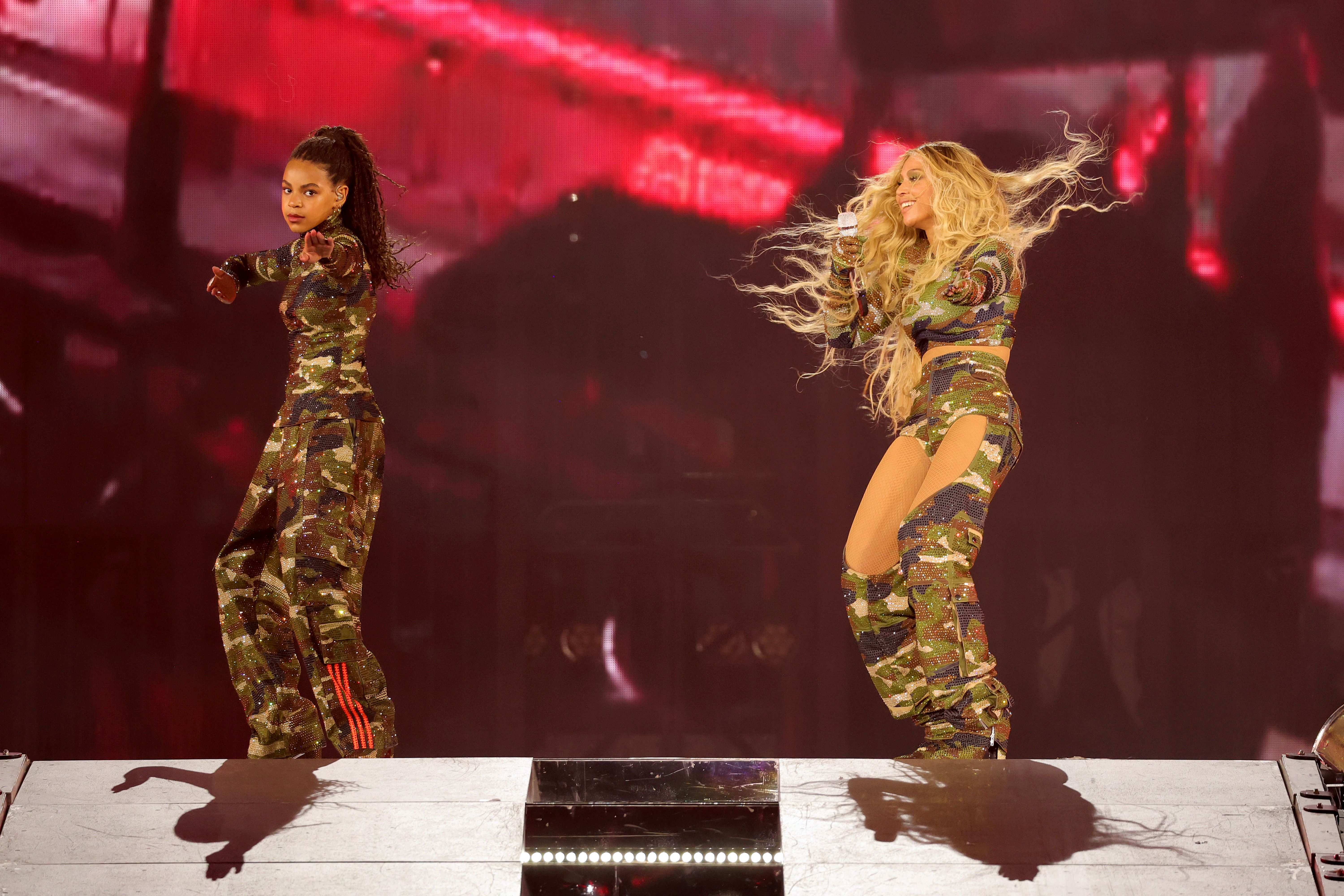 Blue Ivy Carter, 11, wore a camo-print outfit with a long-sleeved turtleneck top and cargo pants, and had her long, braided hair in a high ponytail. She was performing onstage next to her mother, Beyoncé, during the "RENAISSANCE WORLD TOUR" at Mercedes-Benz Stadium on August 11, 2023, in Atlanta, Georgia.
