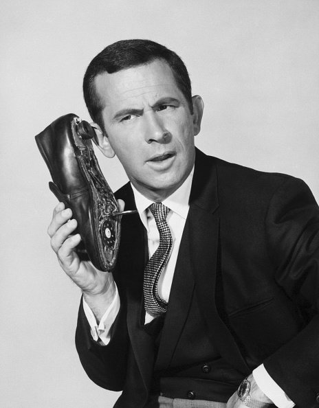 Don Adams, as secret agent "86" Maxwell Smart, talks into his trusty shoe-phone, undated picture. | Photo: Getty Images